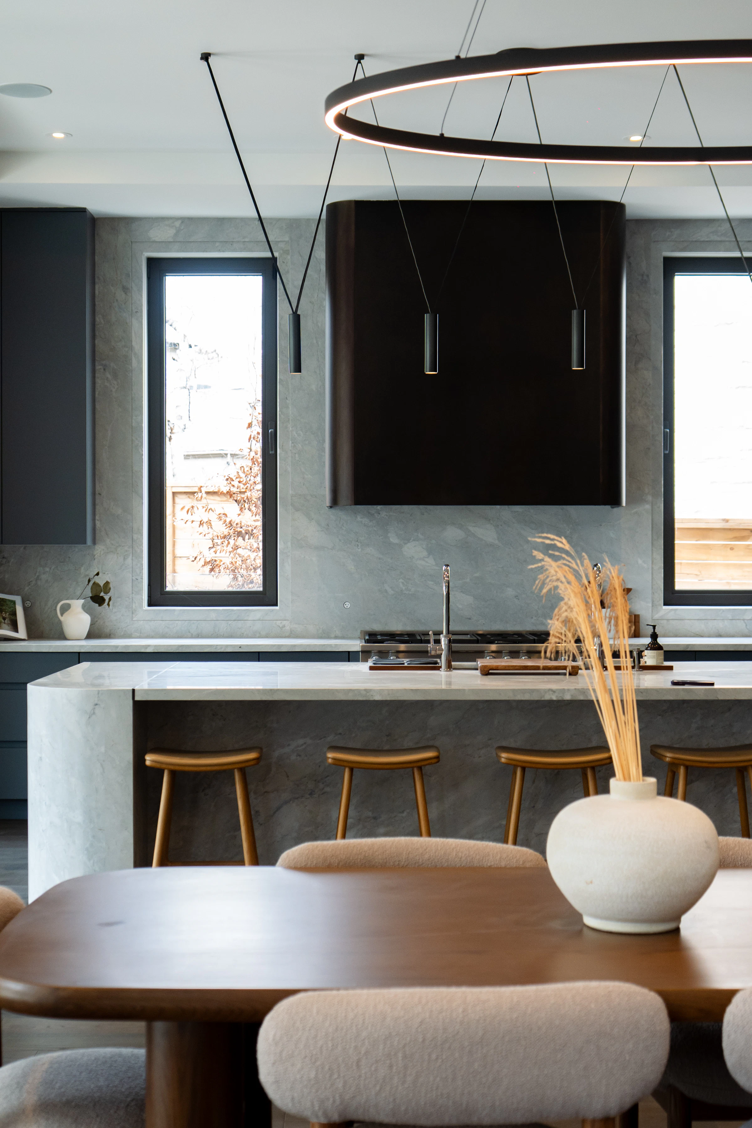 Obsidian kitchen: charcoal cabinetry, waterfall island, dining table