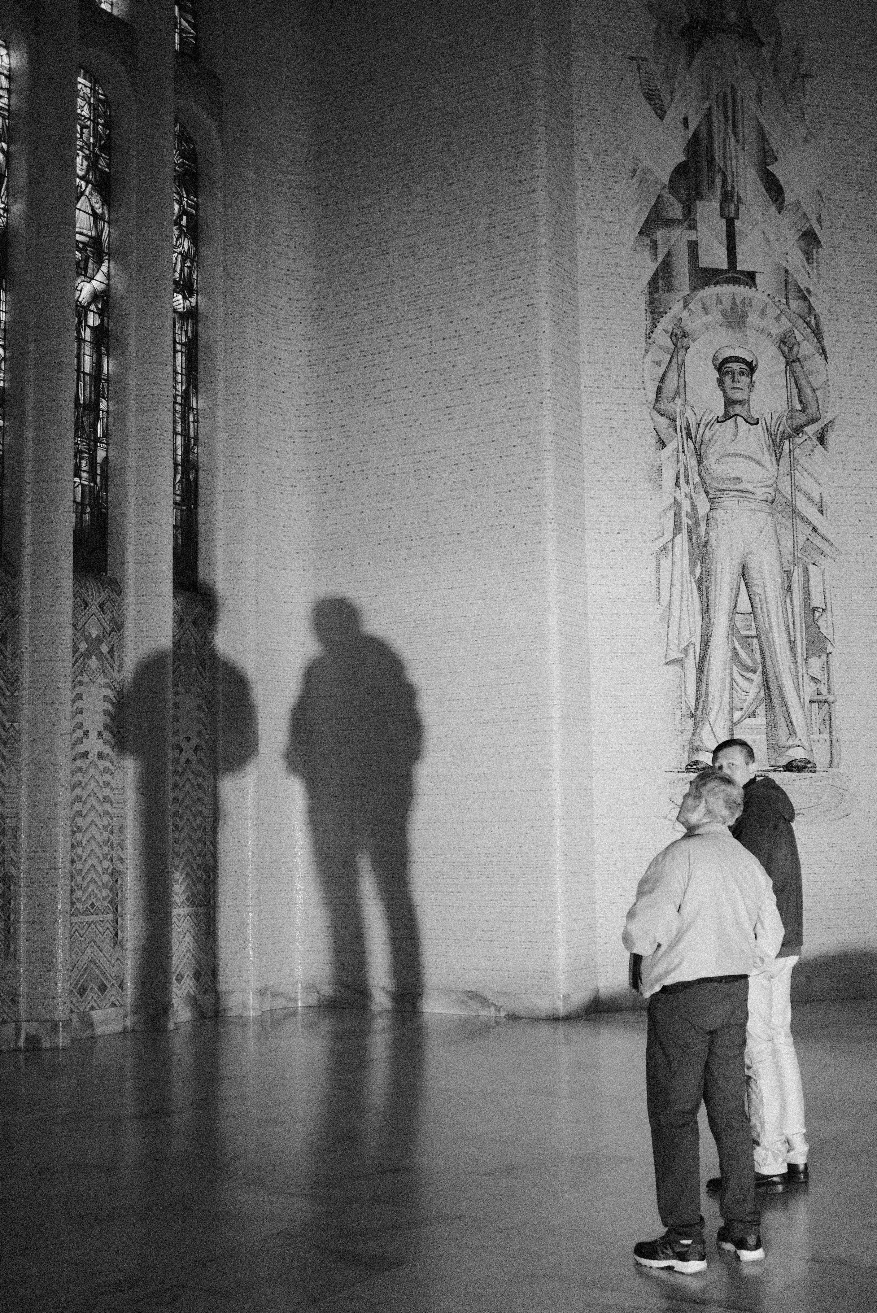 Menschen, die eine Statue in einer großen Halle betrachten.