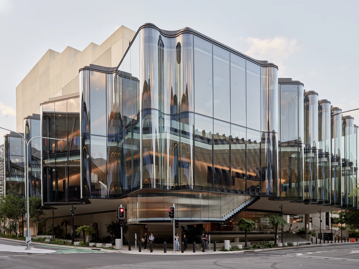 A curved glass architectural facade reflecting soft daylight.