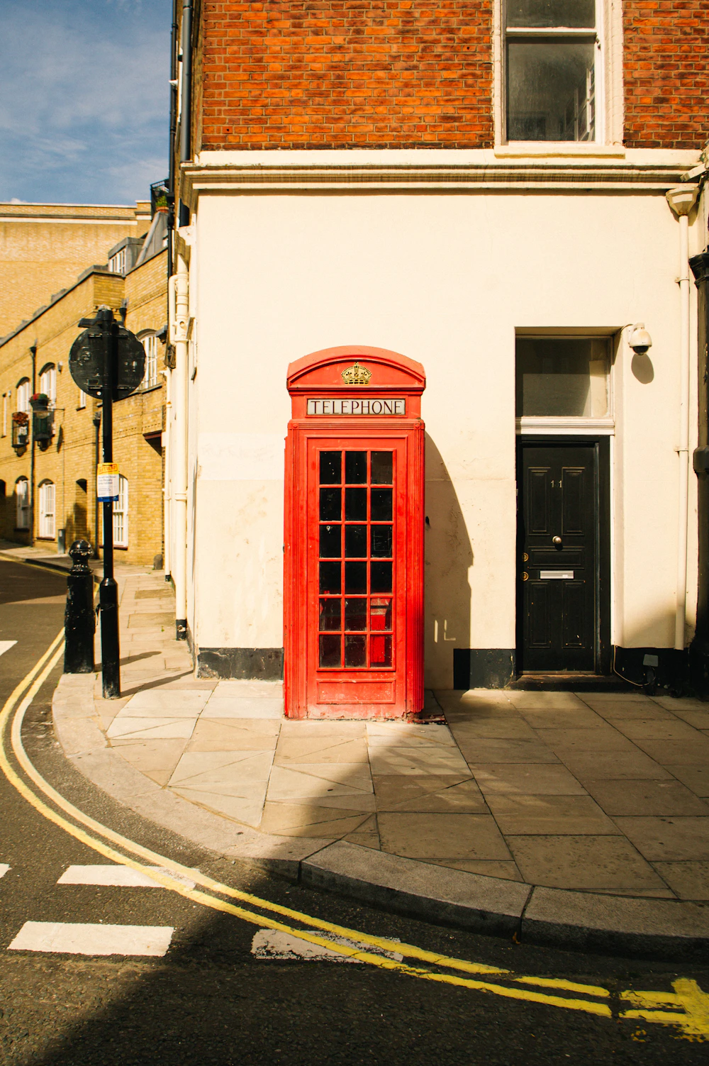 A red telephone box on an elegant Marylebone street