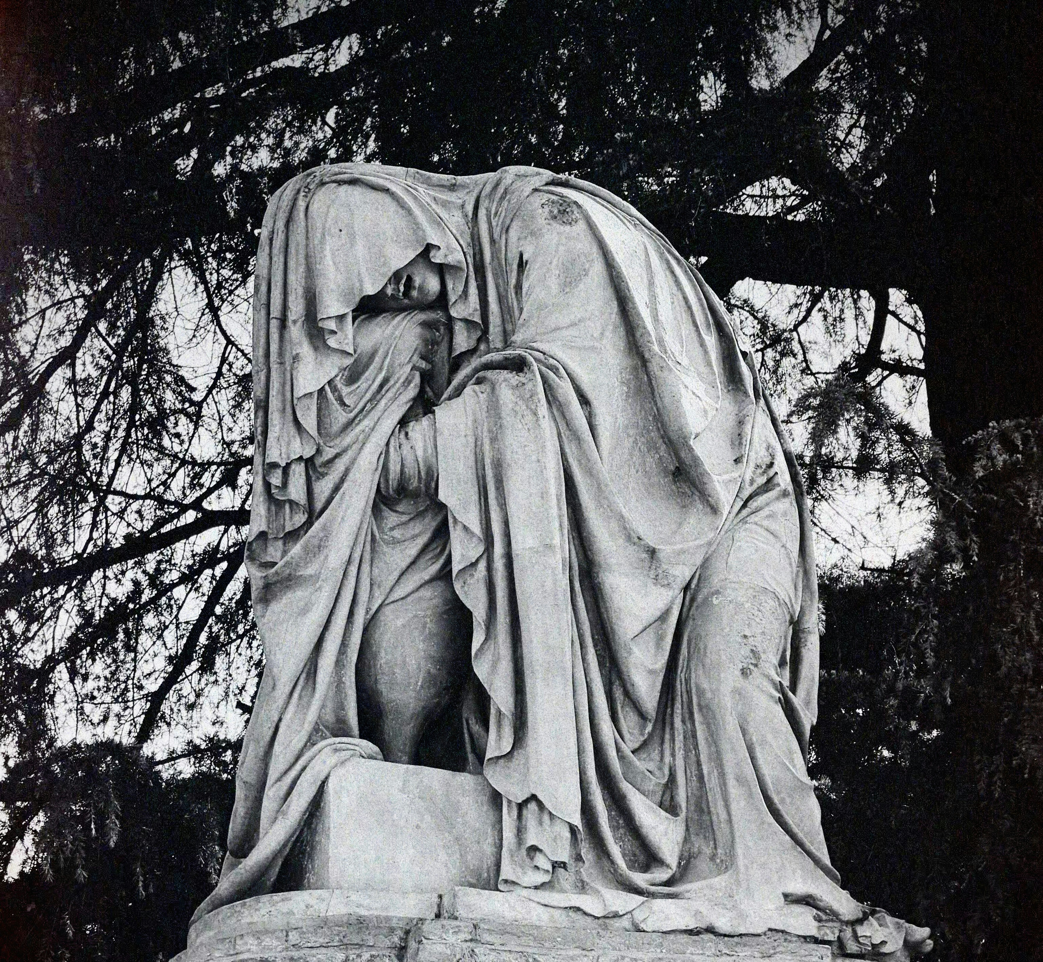 Uma estátua triste envolta em tecido, chorando.