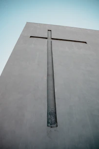 A large cross carved into a concrete wall.