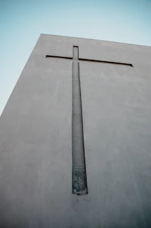 A large cross carved into a concrete wall.