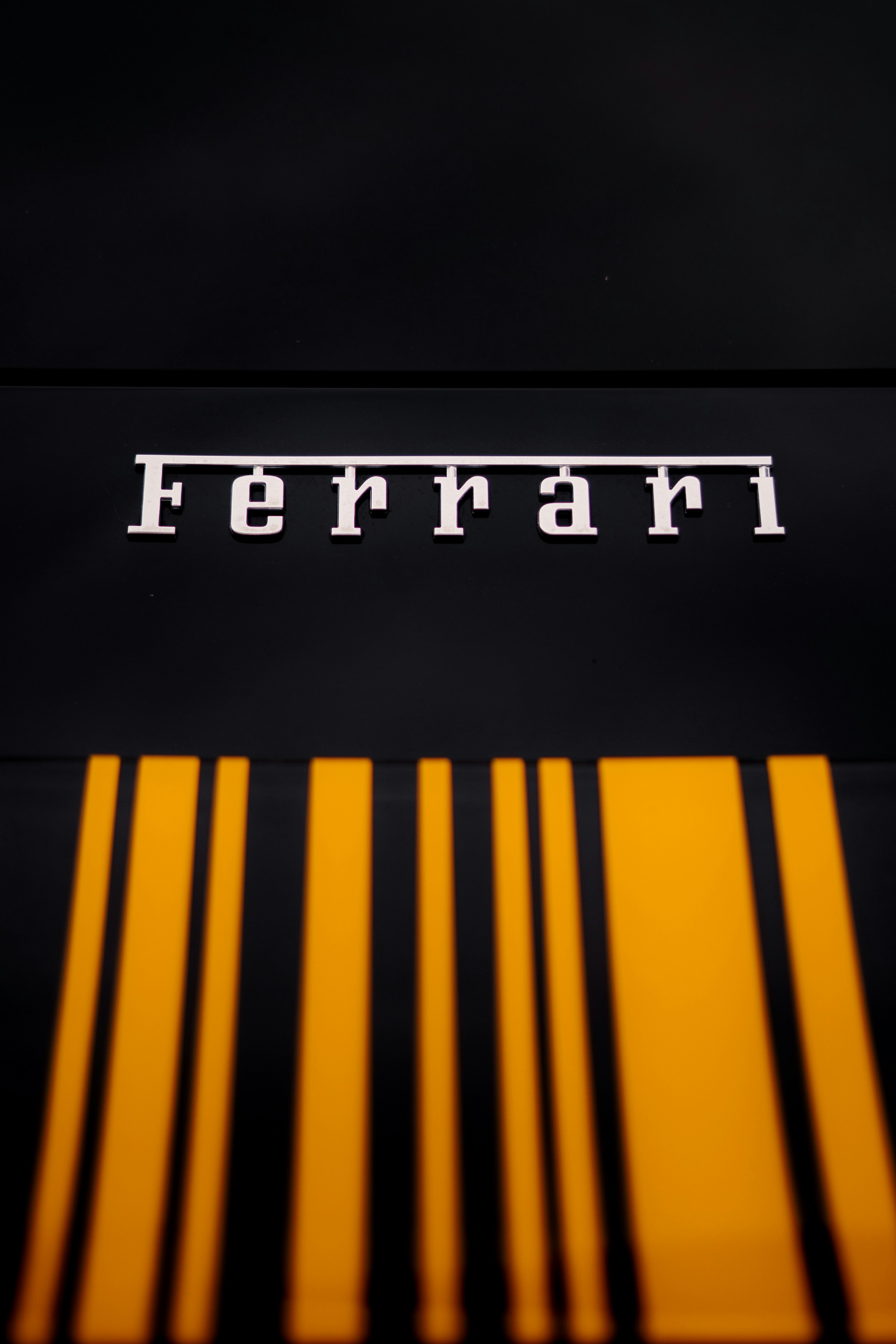 Logo Ferrari dengan garis-garis balap kuning