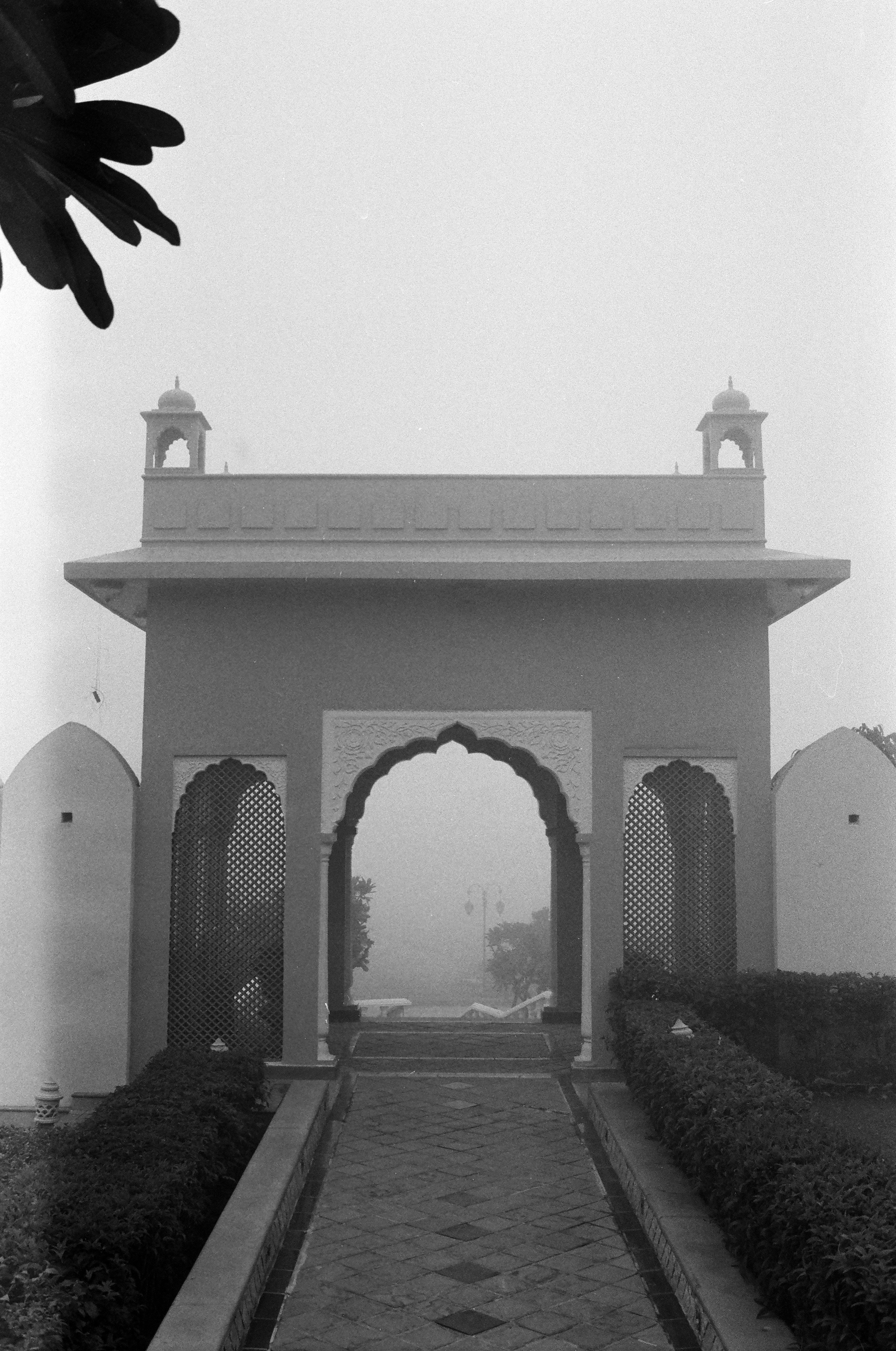 Ornate archway leading into a misty garden