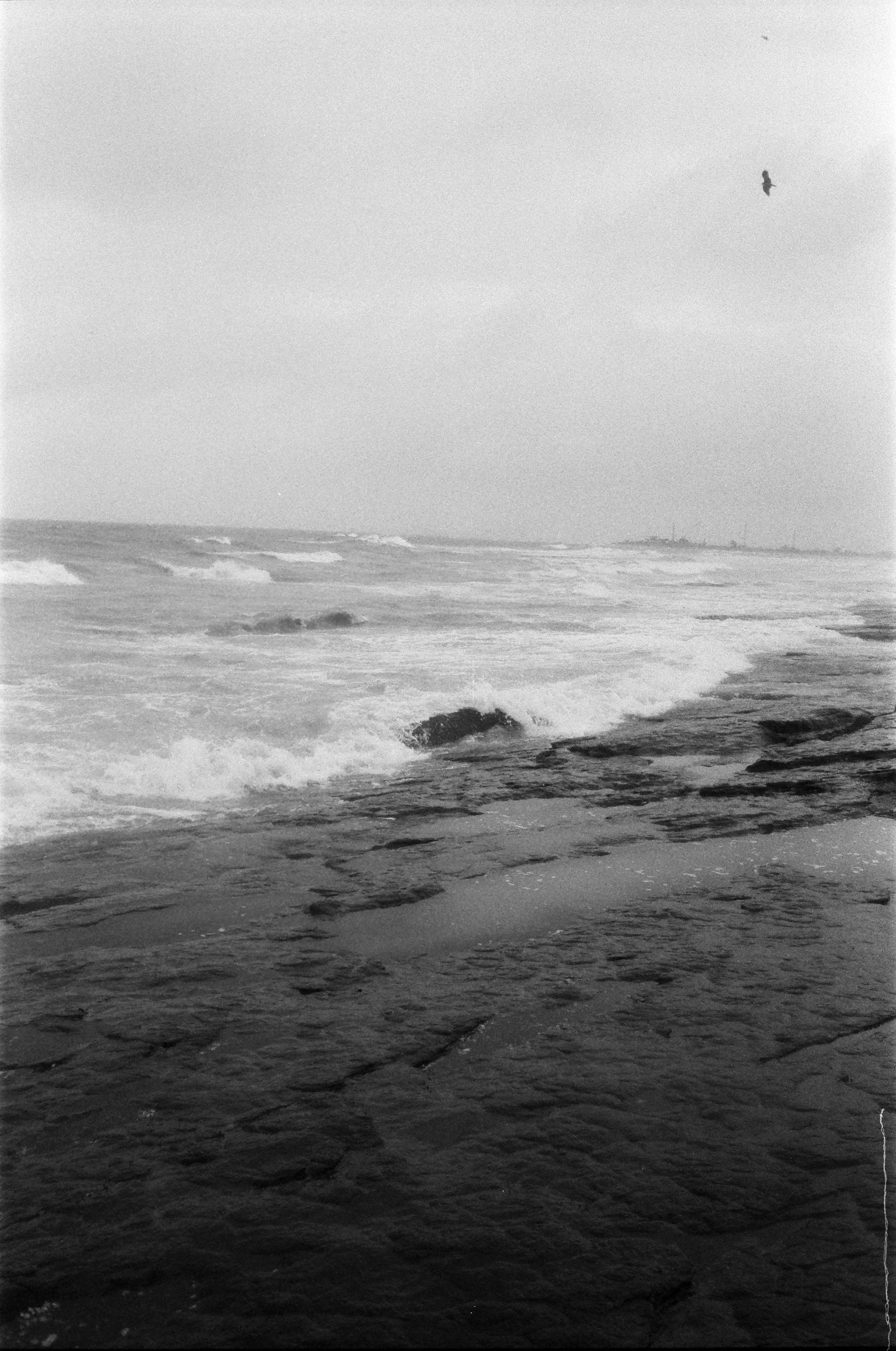 Waves crashing on a rocky shore under a cloudy sky