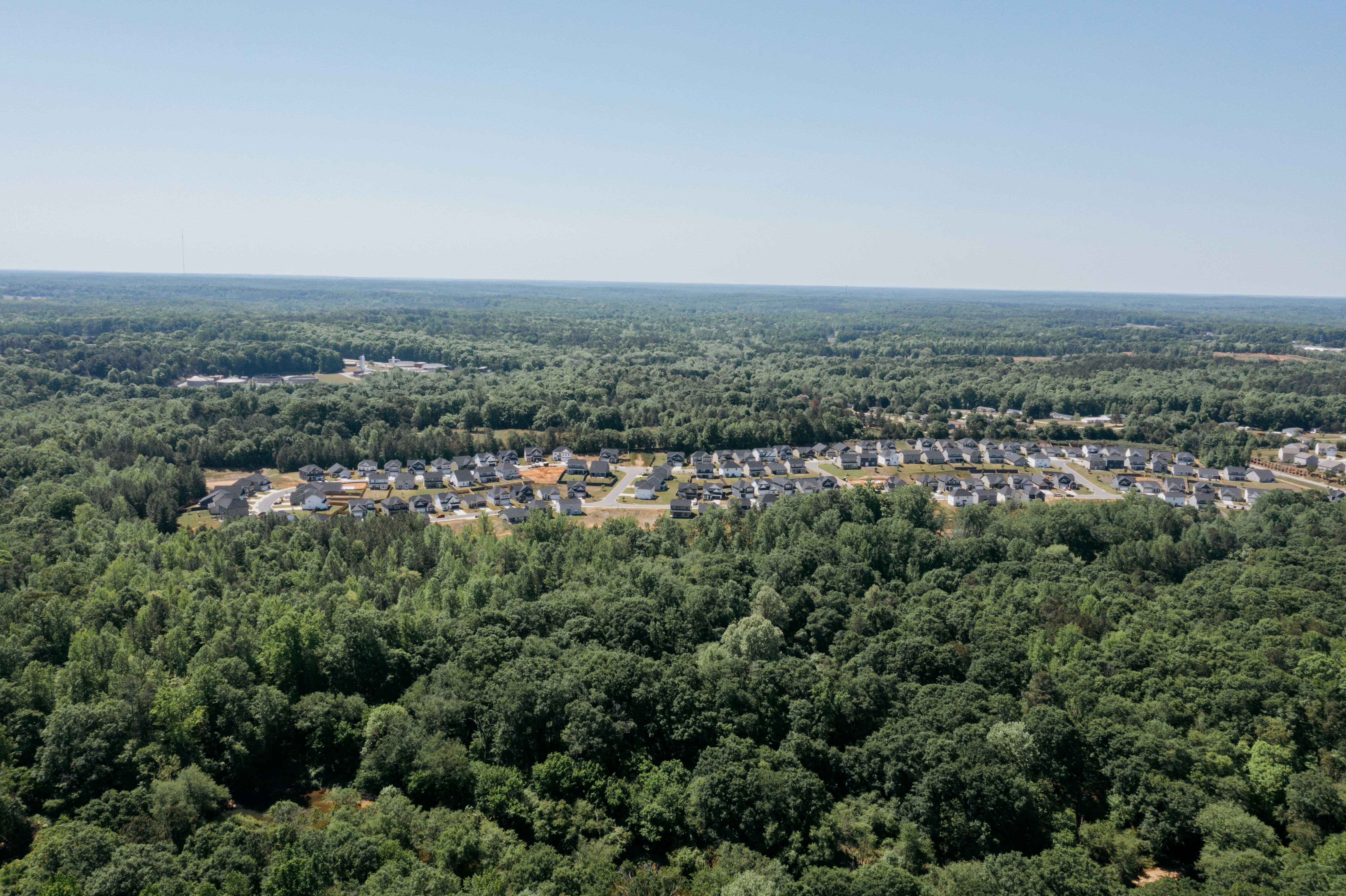 Aerial view of a suburban neighborhood surrounded by trees
