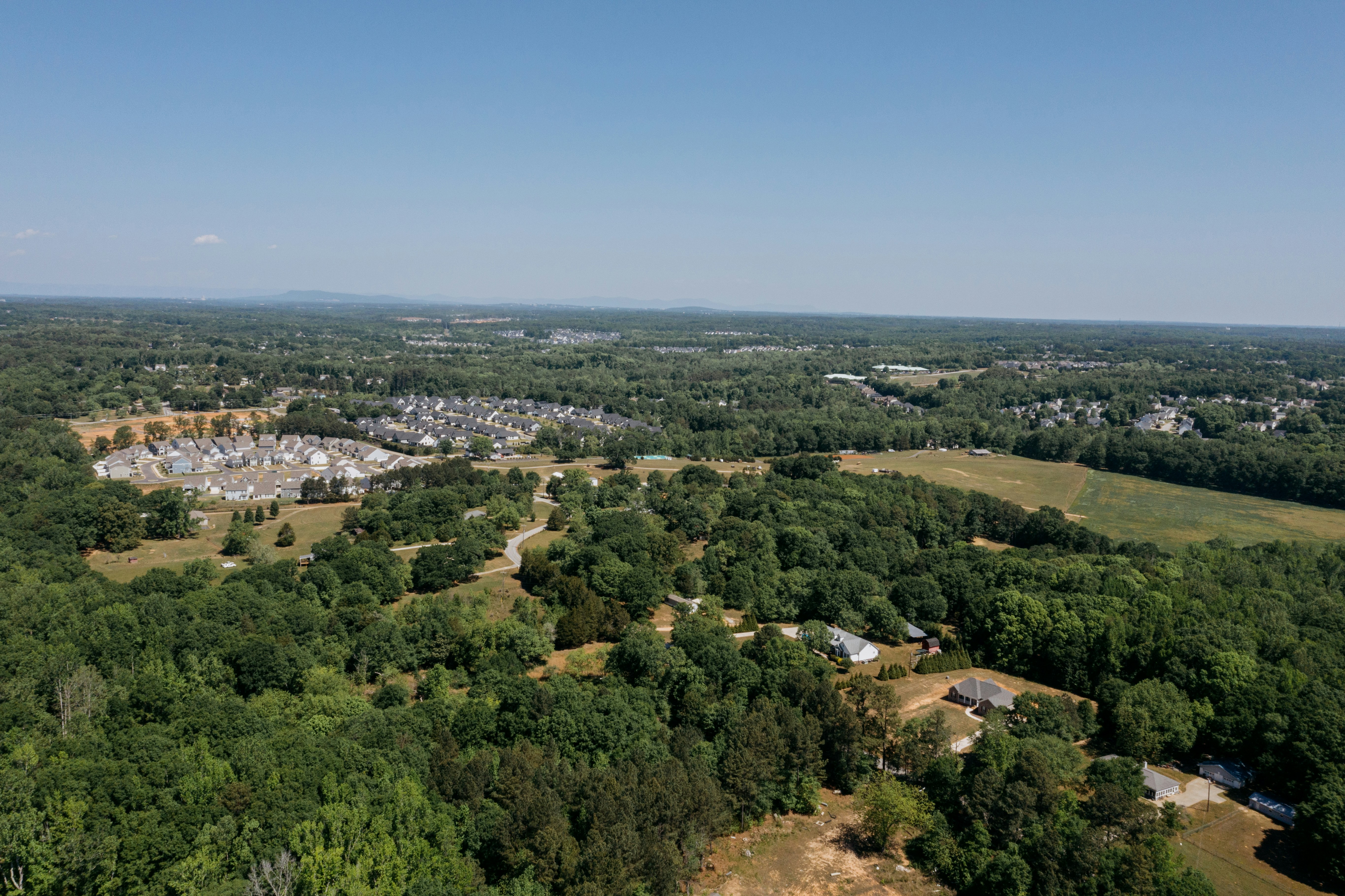 Aerial view of suburban neighborhood surrounded by trees