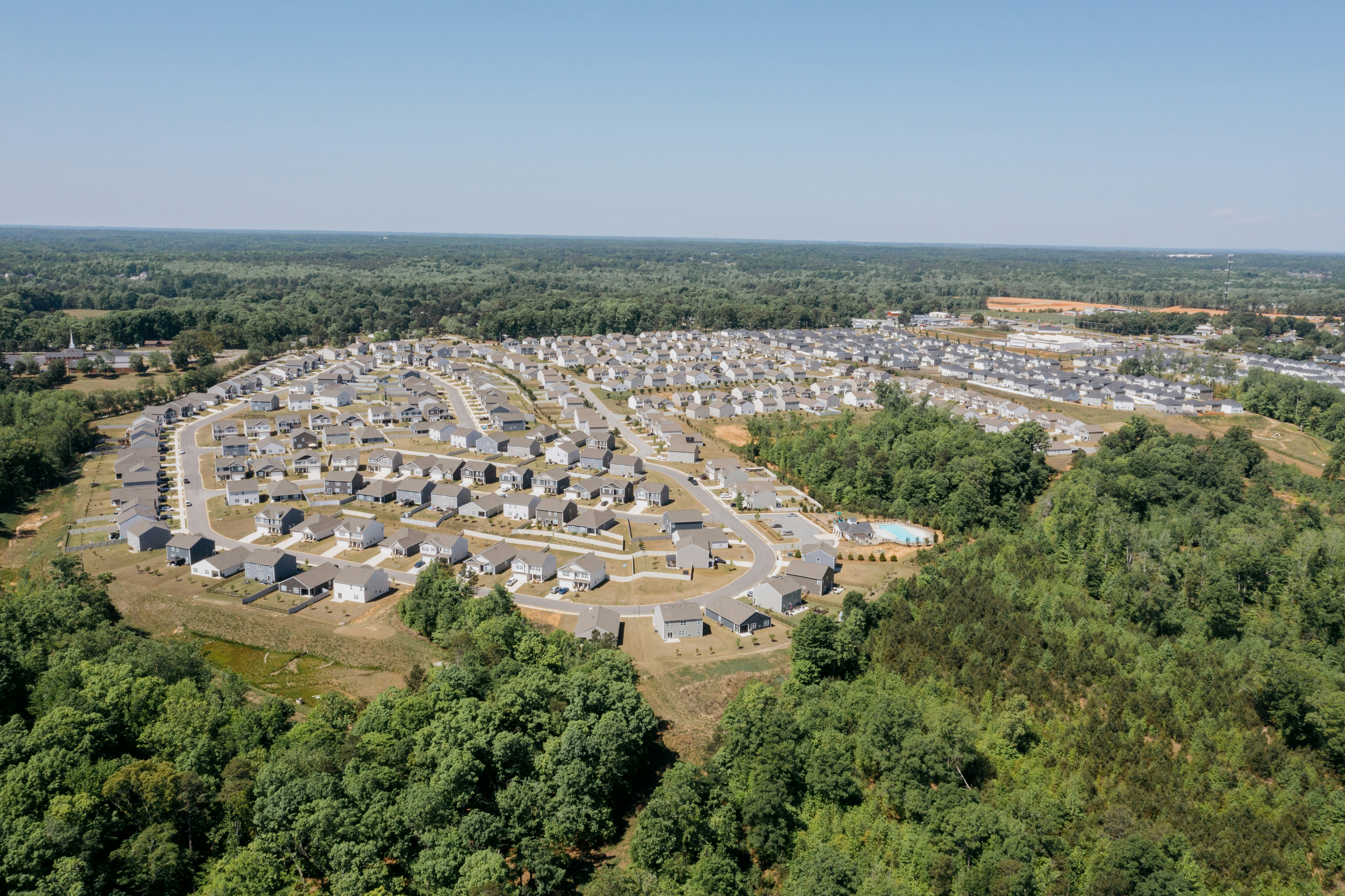 Aerial view of a suburban housing development surrounded by trees