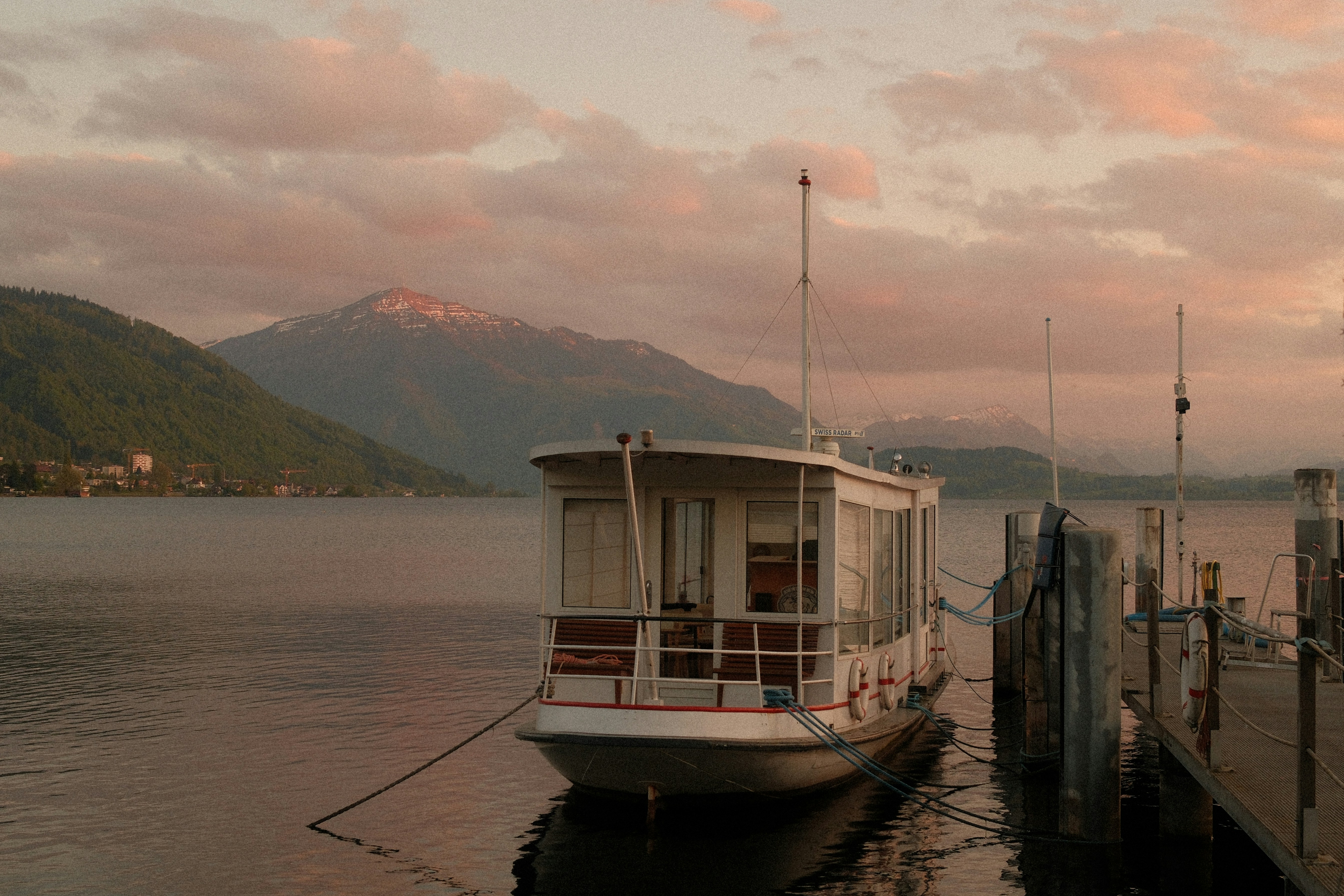 A boat docked on a calm lake at sunset