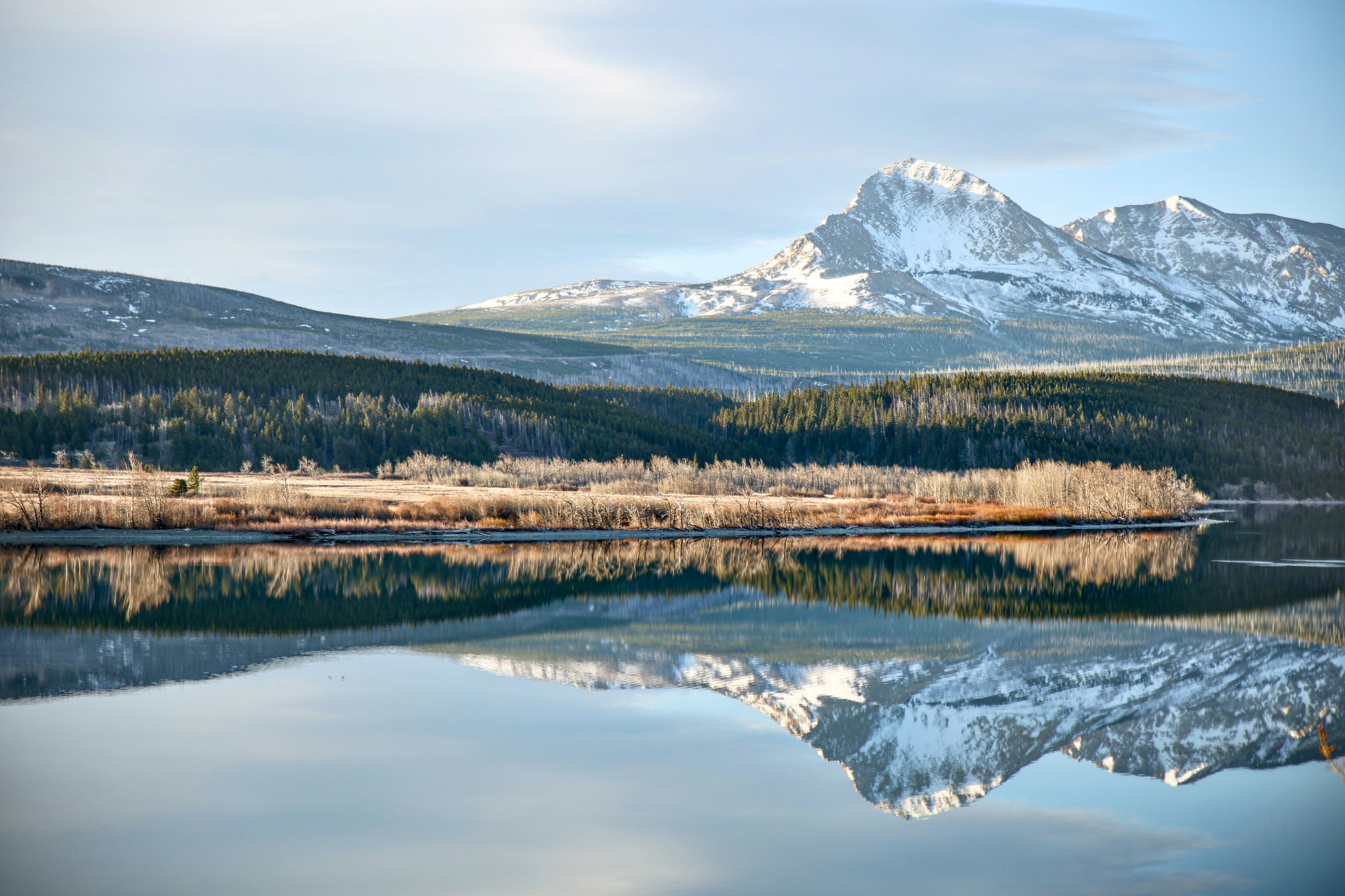 Snow-capped mountains reflected in a calm lake.