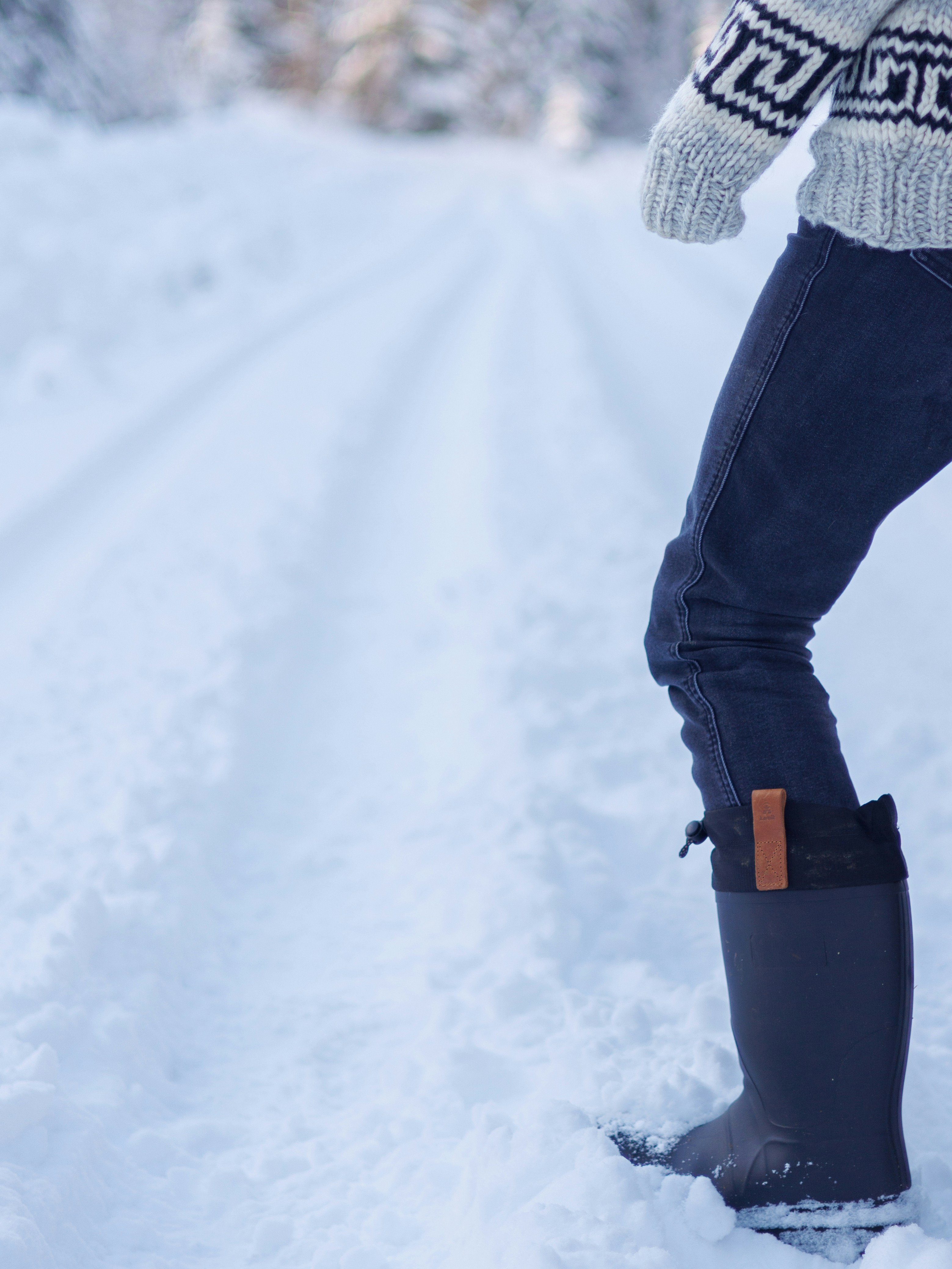 A person walks on a snowy path in winter