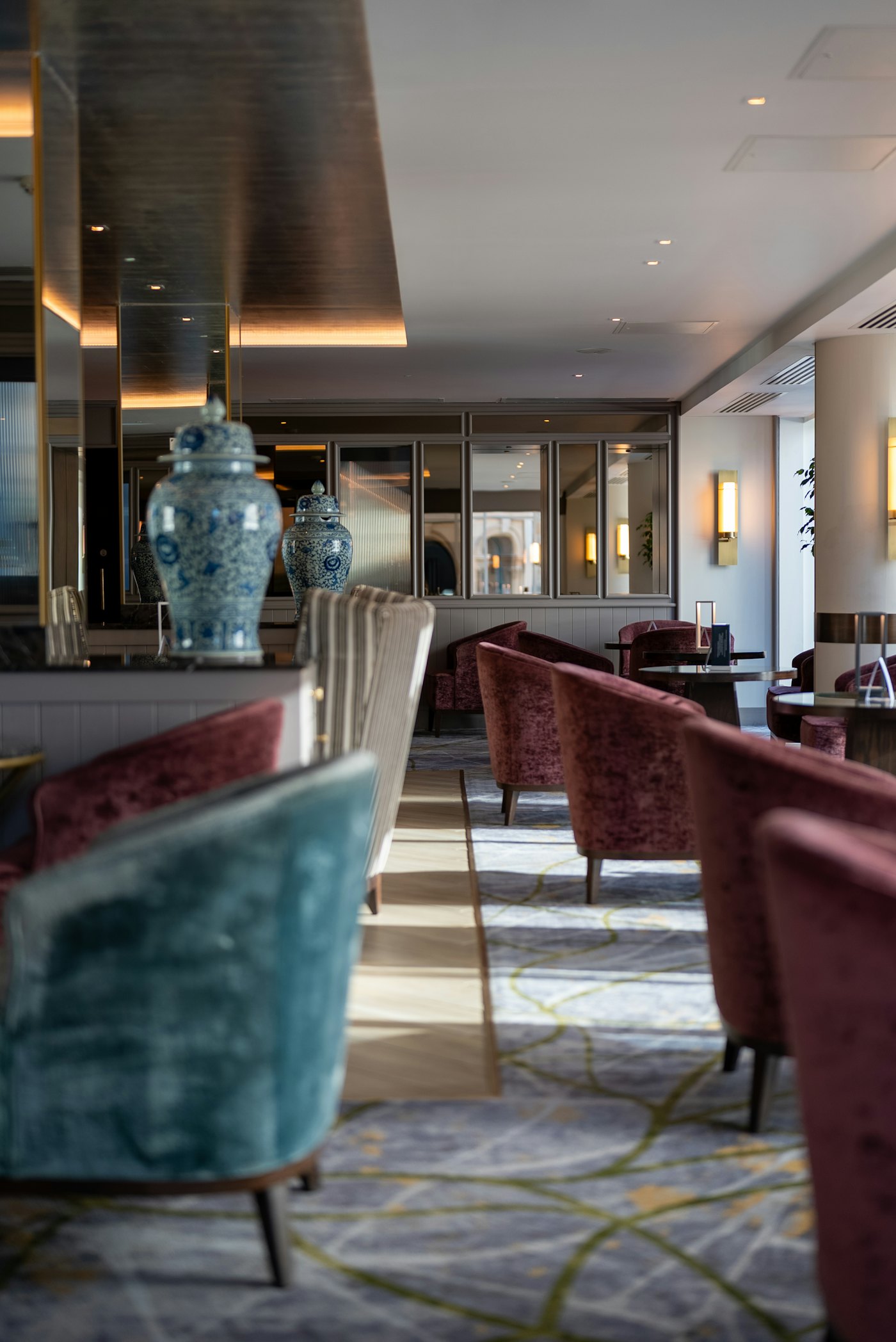 An elegant lounge with plush velvet chairs, low tables and decorative vases