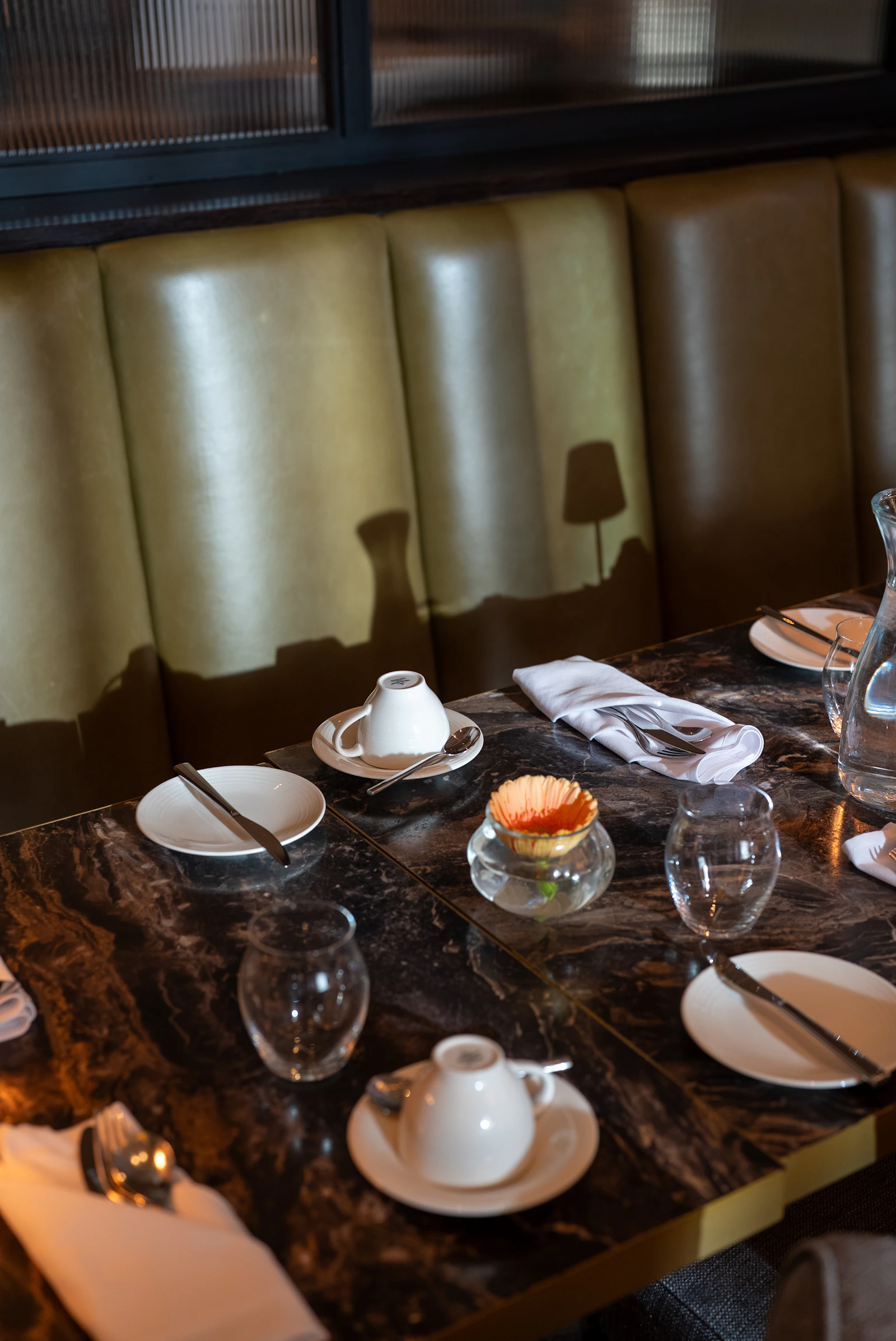 Elegant dining table arranged with cups, glasses, plates, and cutlery