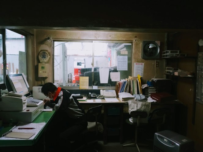 Person sorting mail and documents into folders at a kitchen table
