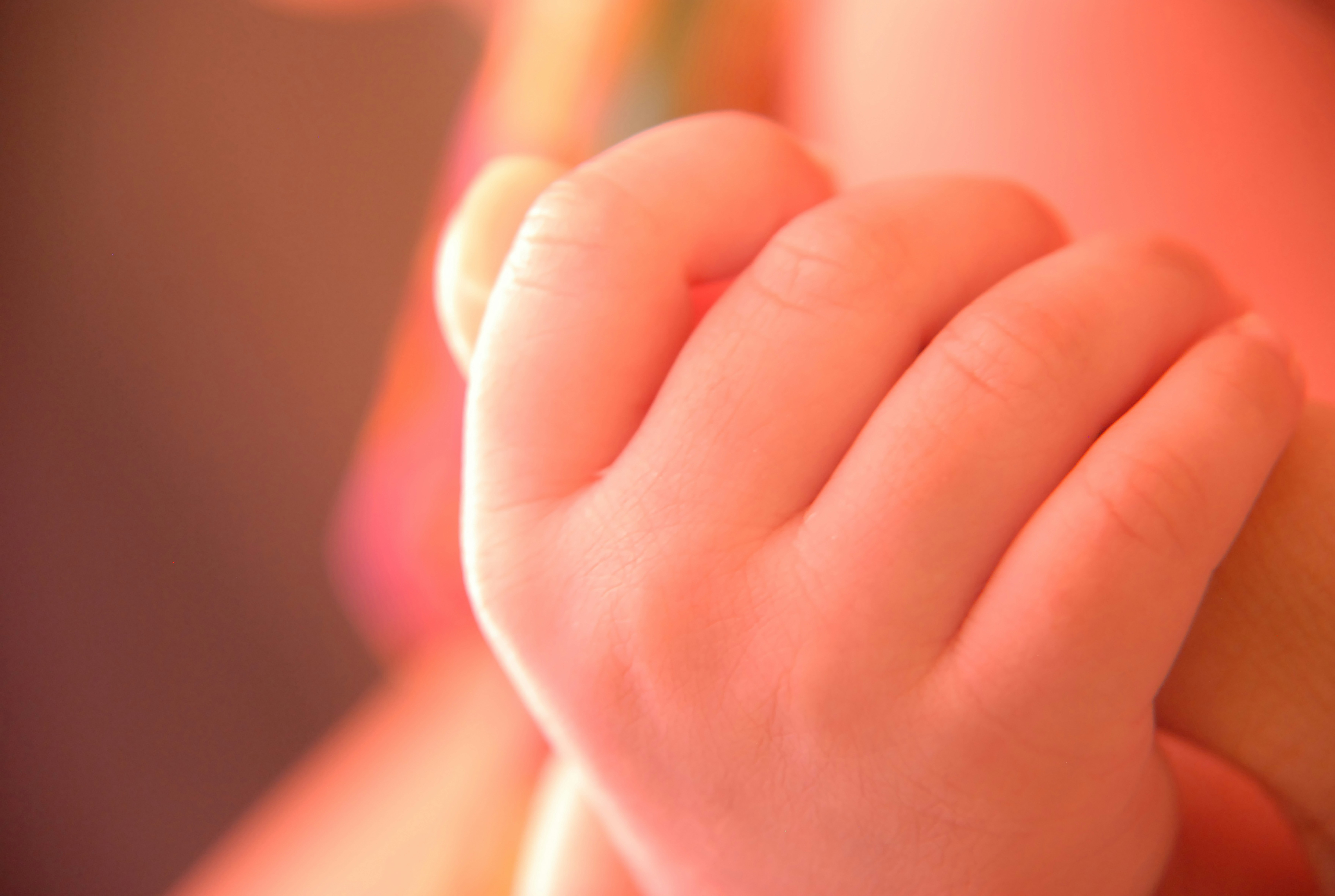 La petite main d’un bébé tient un doigt.
