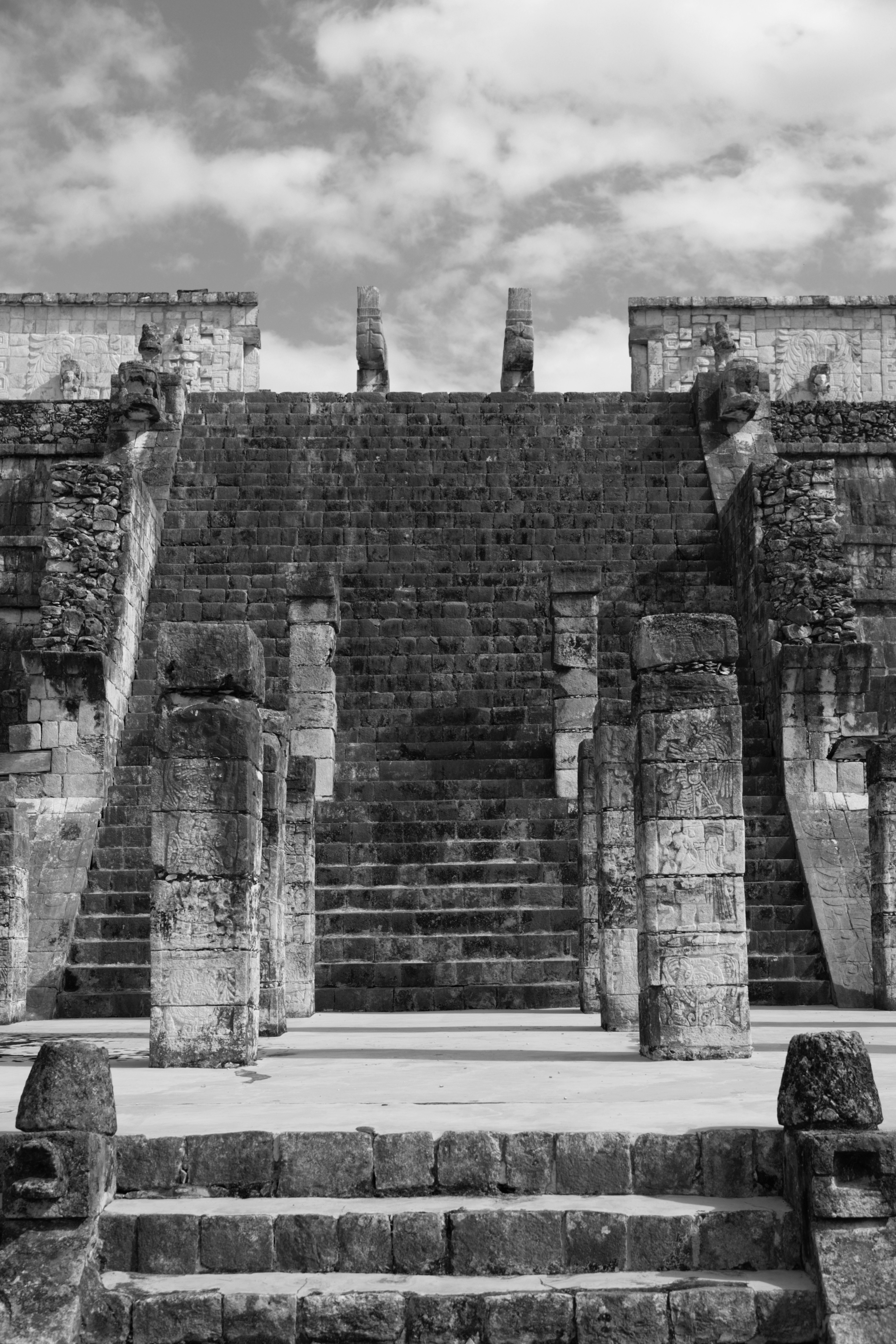 Ancient stone ruins with grand staircases and cloudy sky