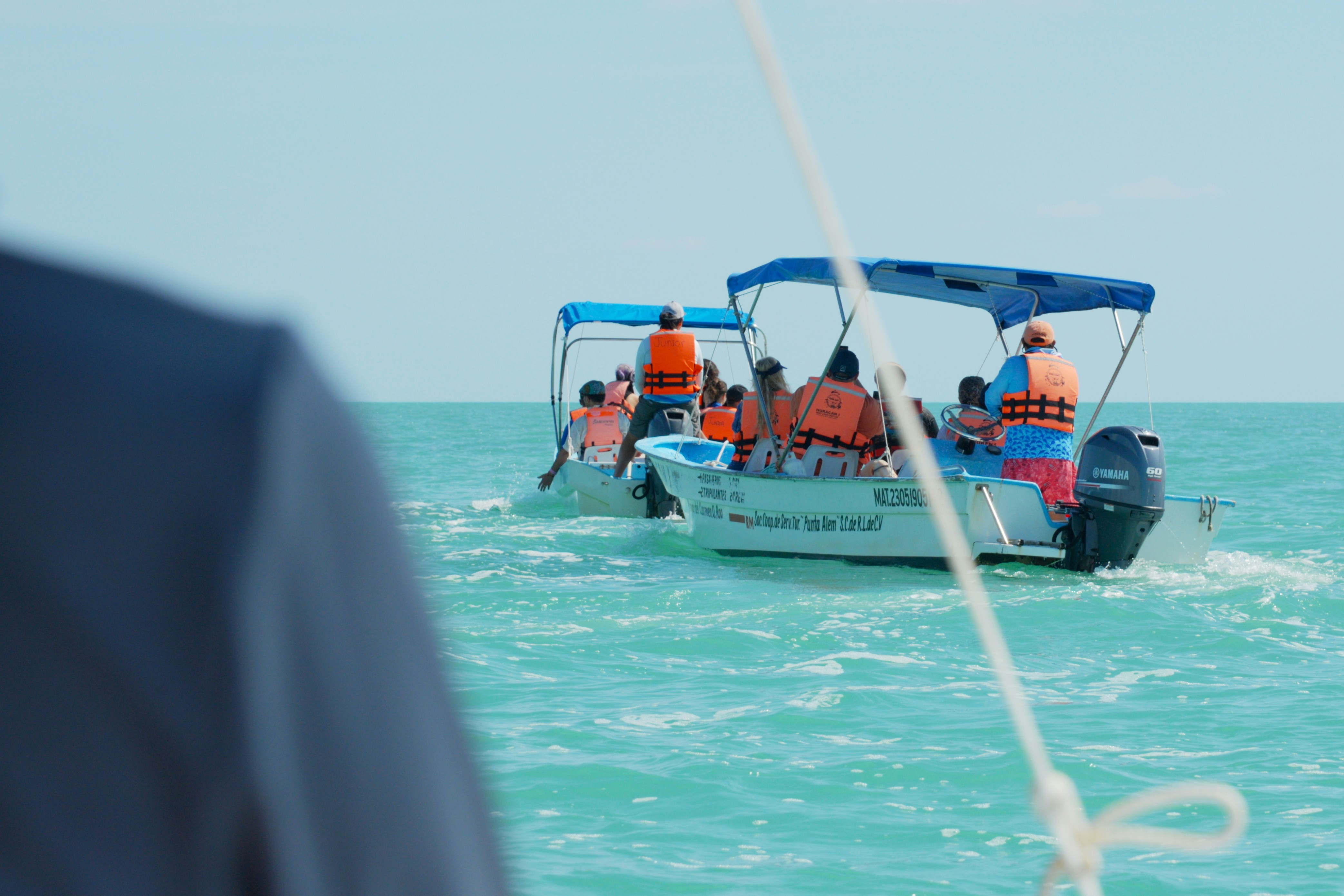 People in boats on the turquoise ocean water