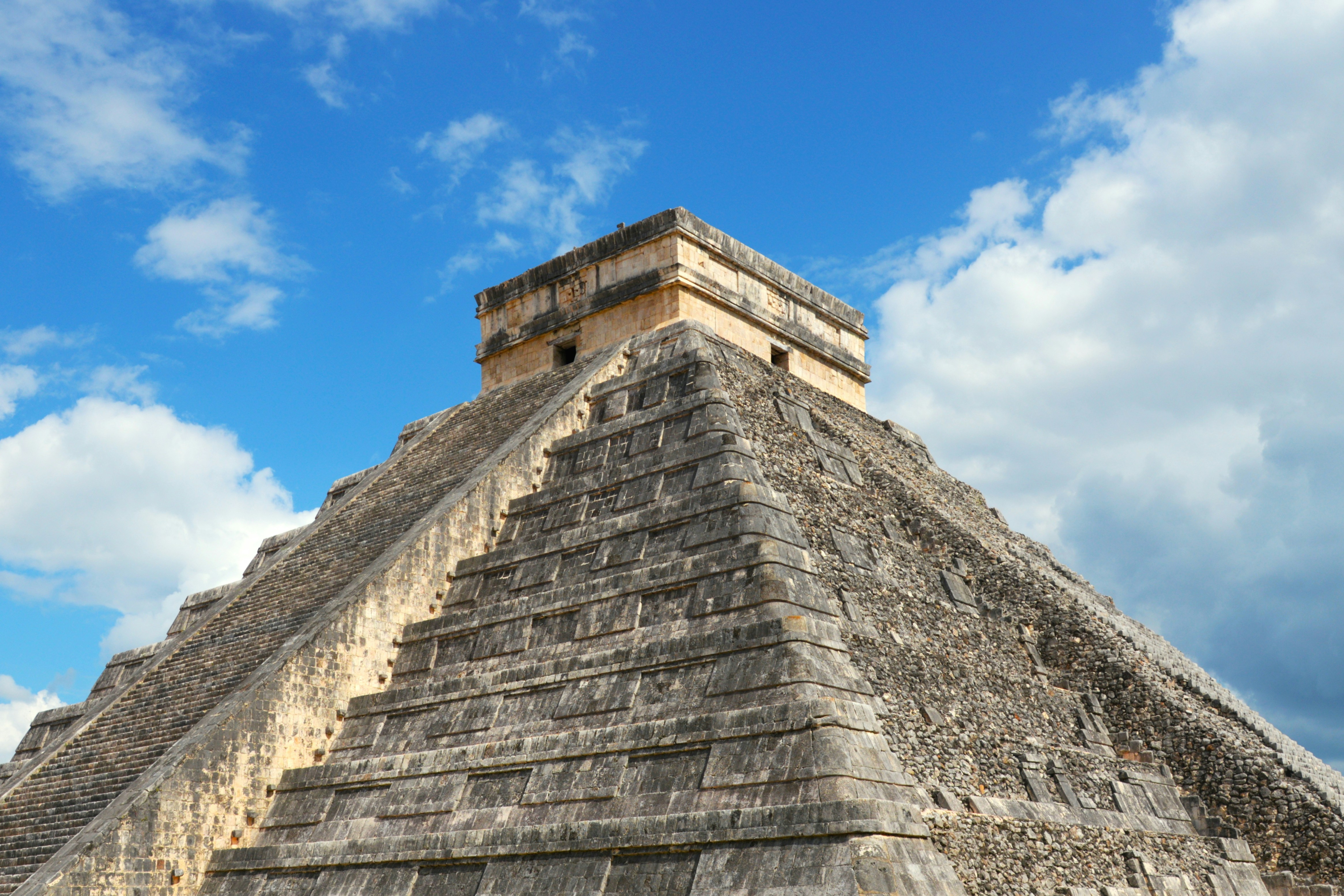 El castillo pyramid under a blue sky with clouds