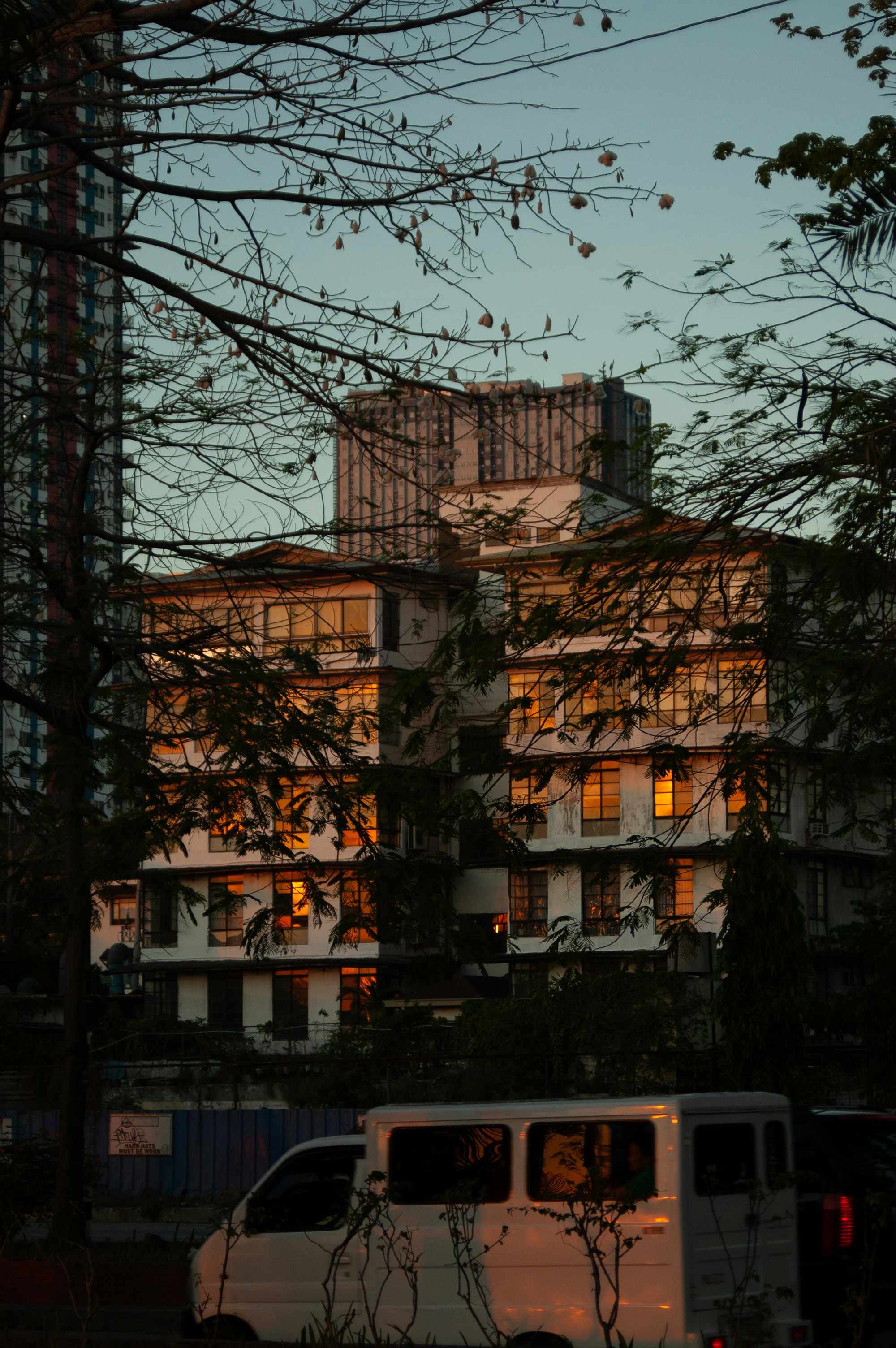 Furgoneta blanca aparcada cerca de los edificios al anochecer
