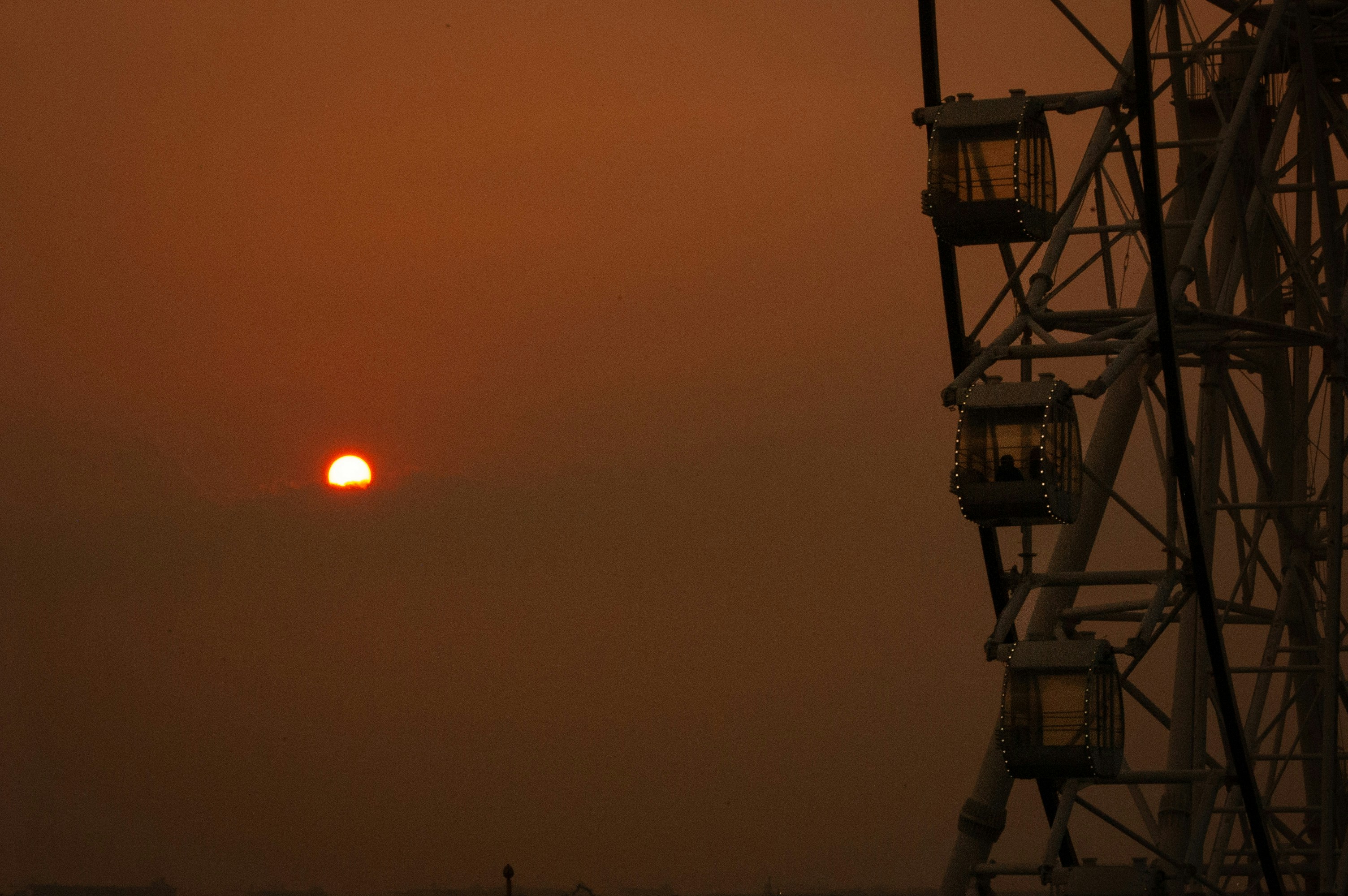 Noria contra un cielo brumoso y atardecer