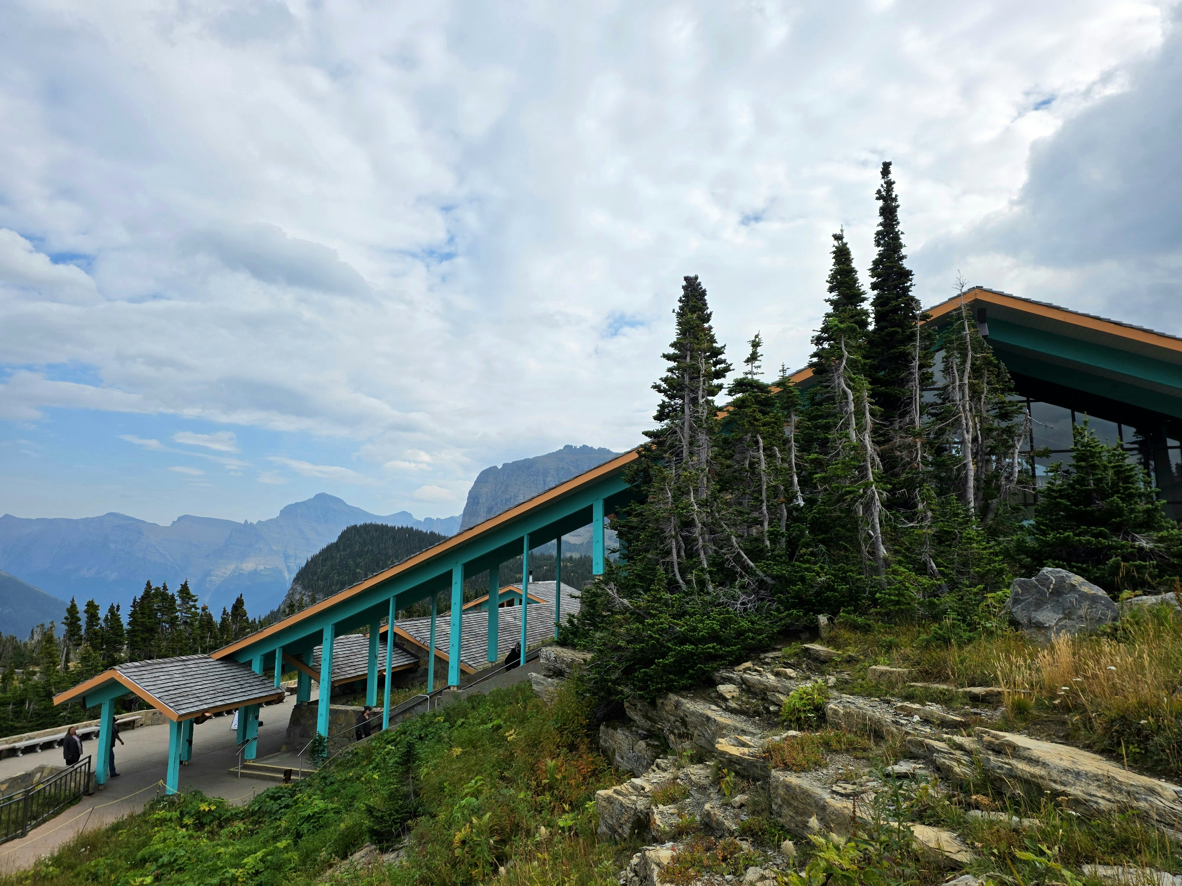 A scenic mountain overlook with trees and cloudy sky
