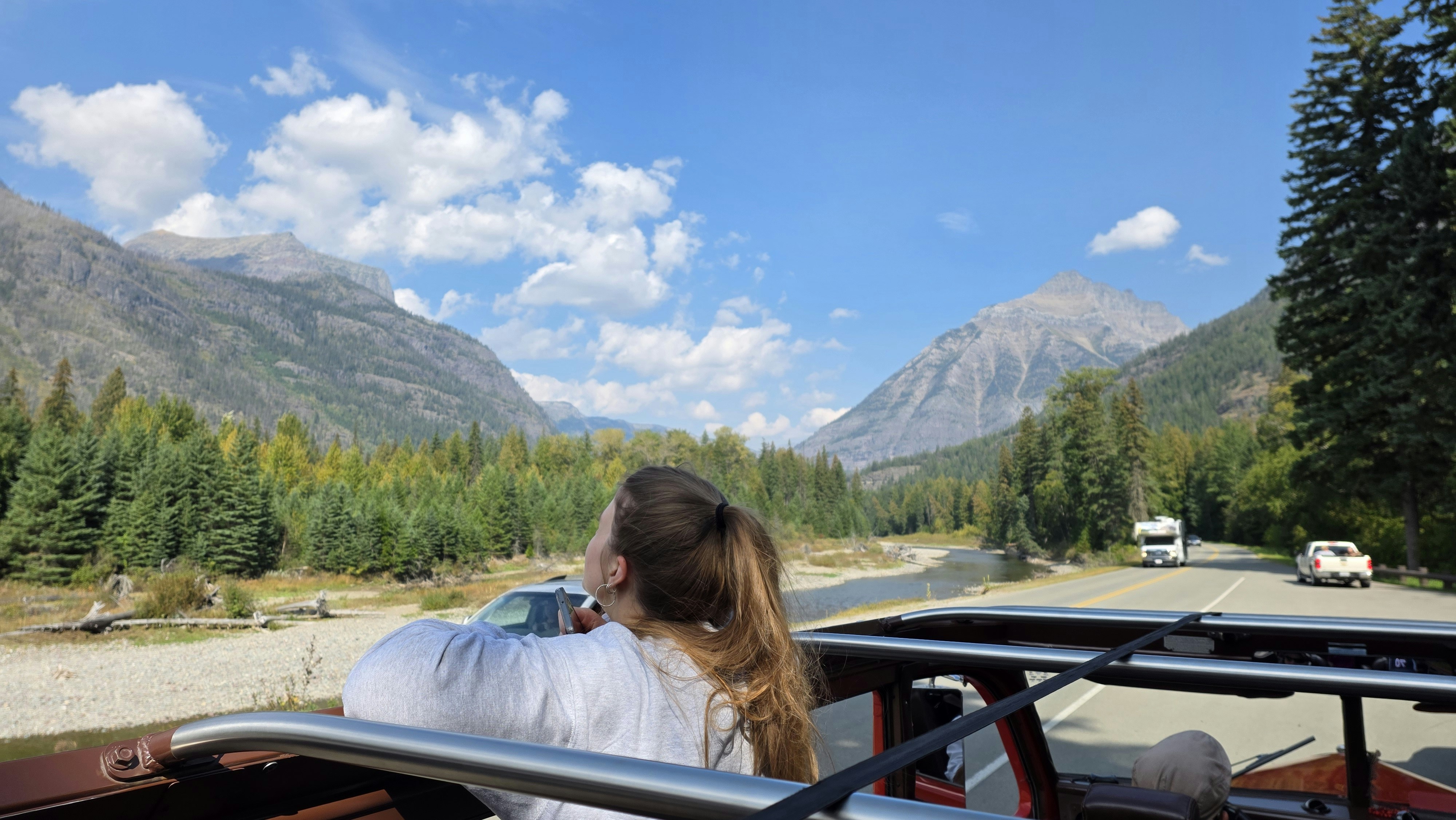 Woman enjoying scenic mountain road trip in convertible