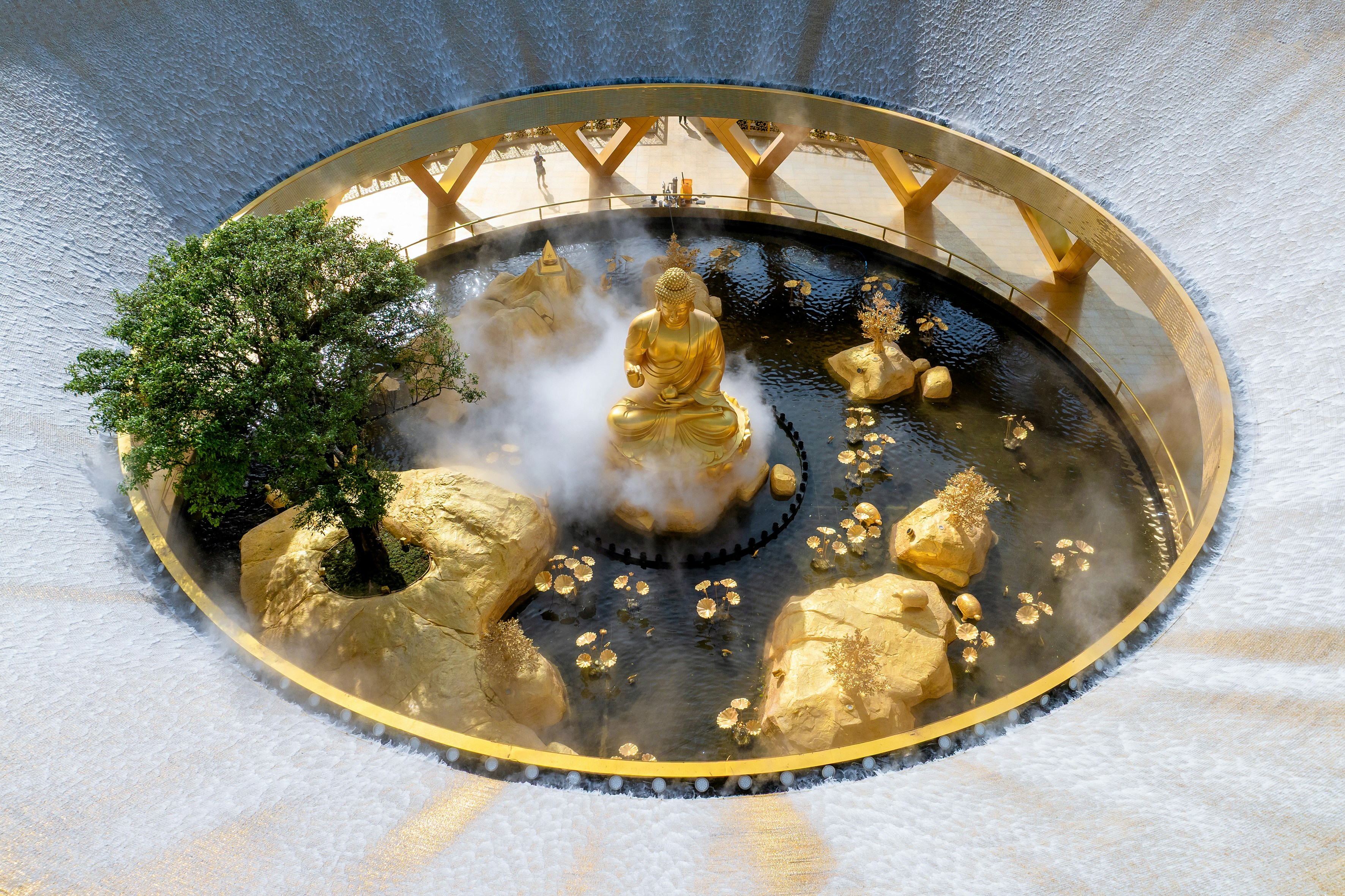 Jardim zen com estátua dourada de Buda e árvore bonsai