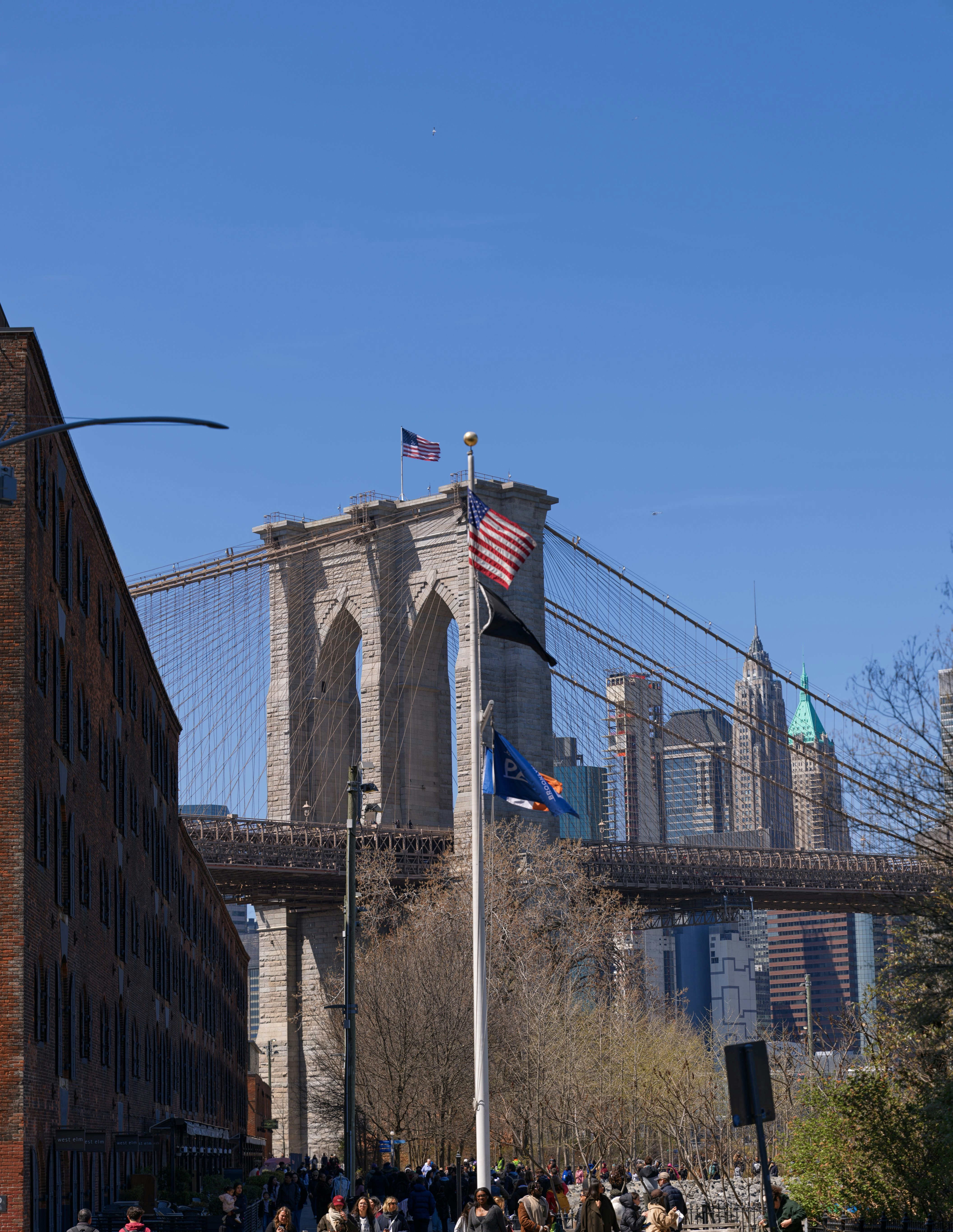 Puente de Brooklyn con banderas americanas y skyline de la ciudad.