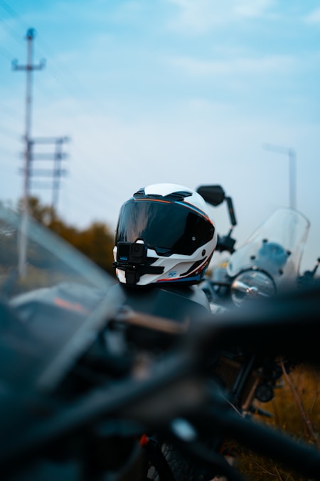 White full-face motorcycle helmet with tinted visor resting on a bike