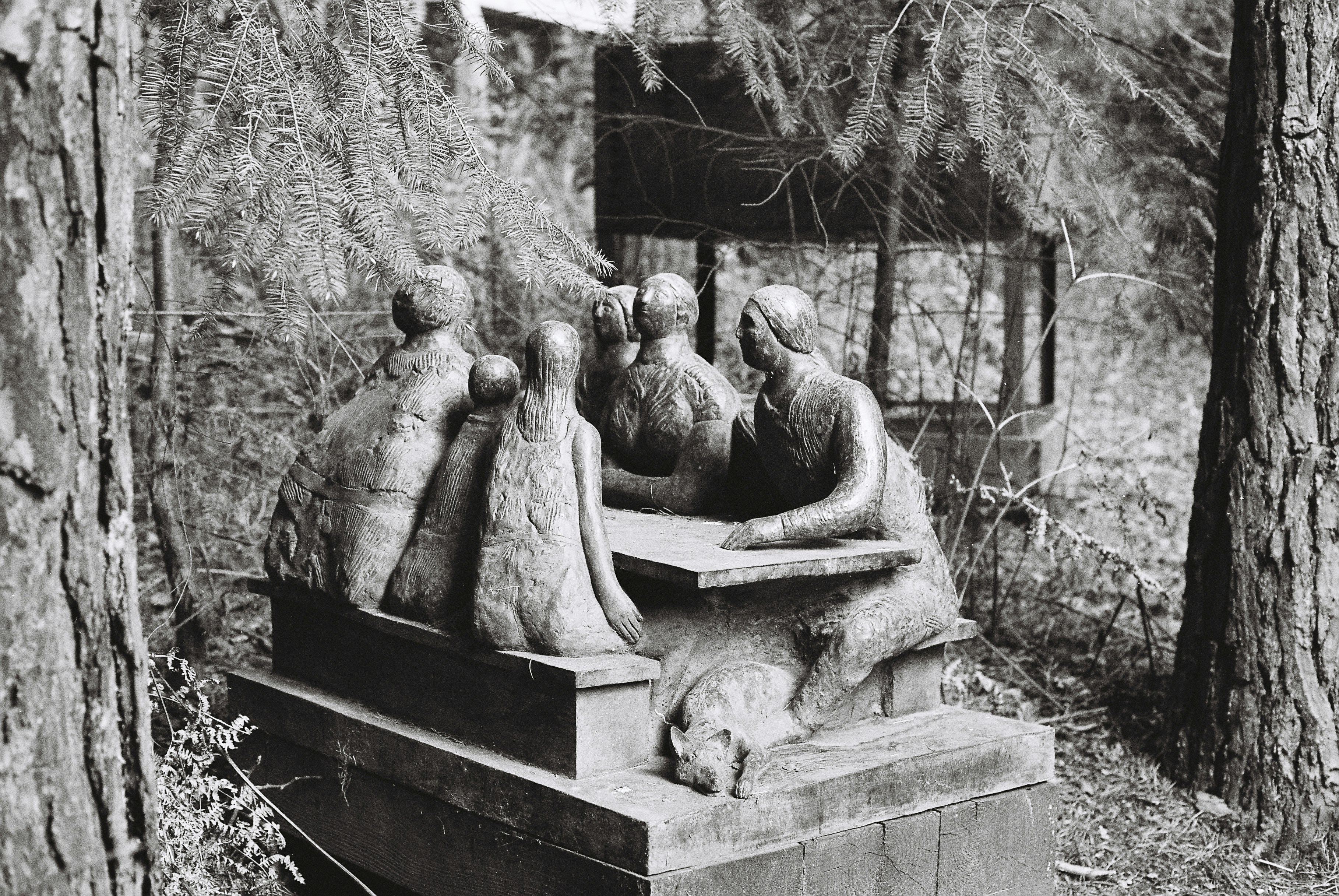 Sculpture de personnes rassemblées autour d’une table à l’extérieur