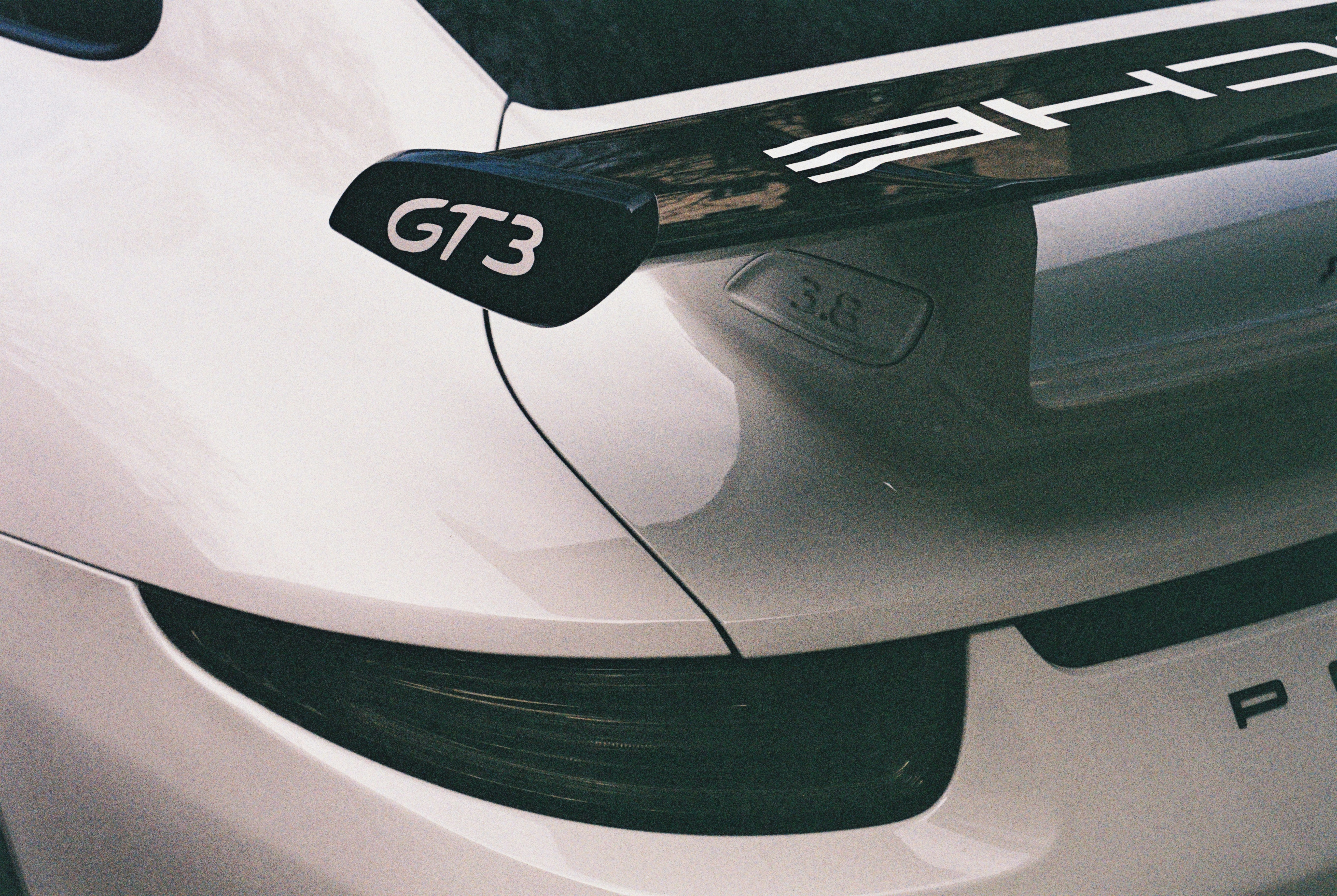 Close-up of a white porsche gt3 rear spoiler.
