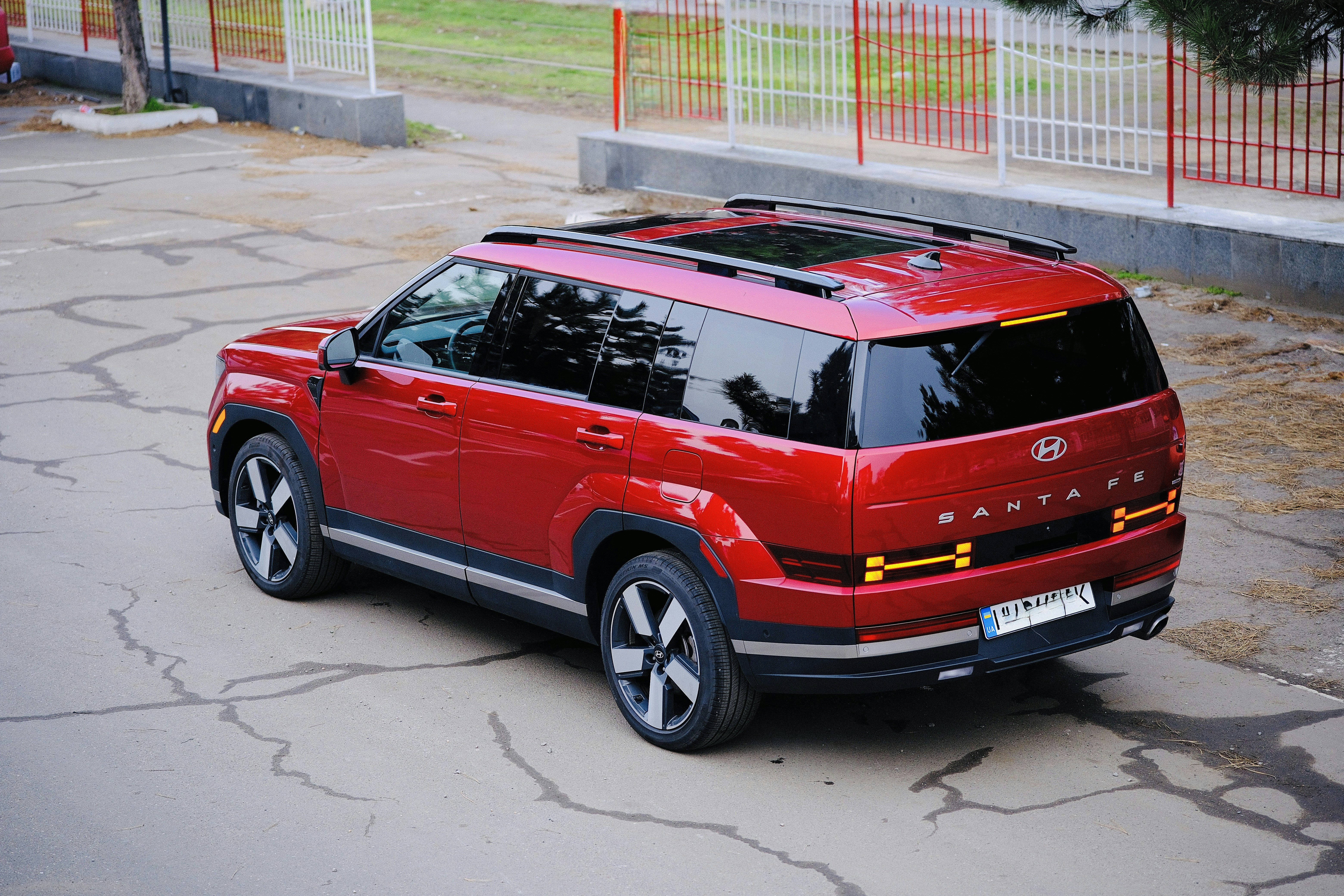 Roter SUV auf einer gepflasterten Fläche geparkt.
