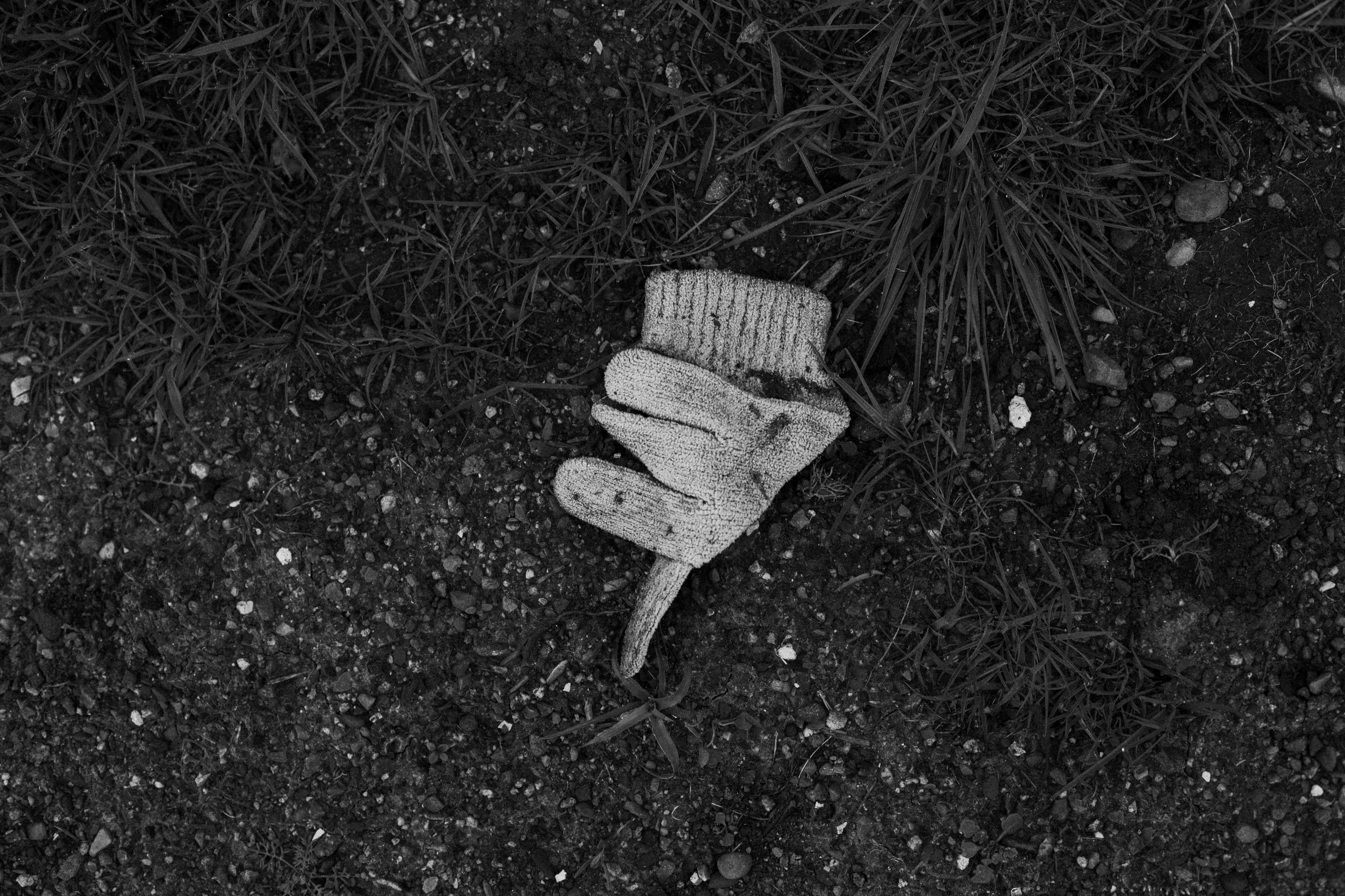 A worn glove lies on the ground.