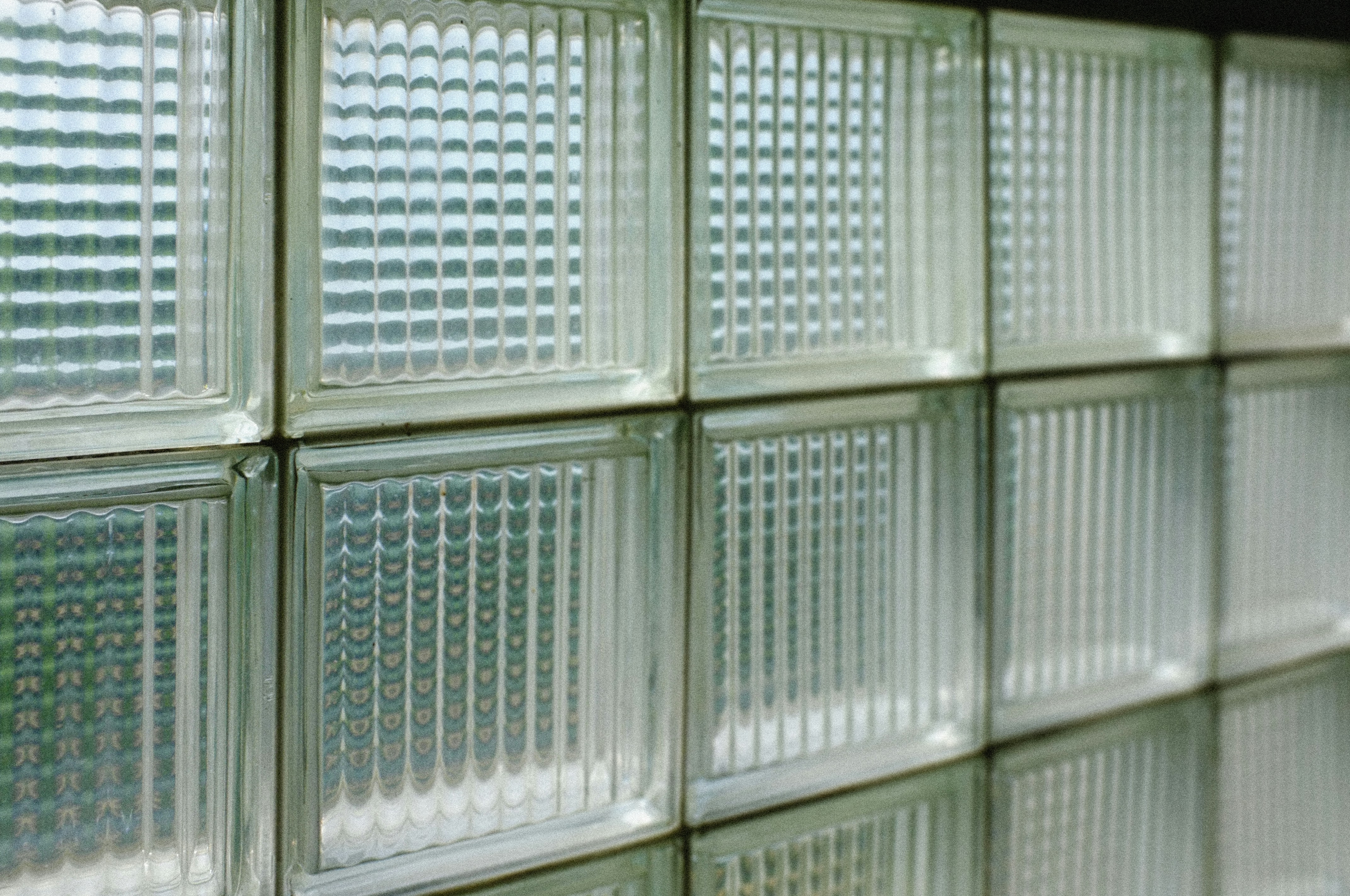 Mur de blocs de verre texturés avec des reflets.