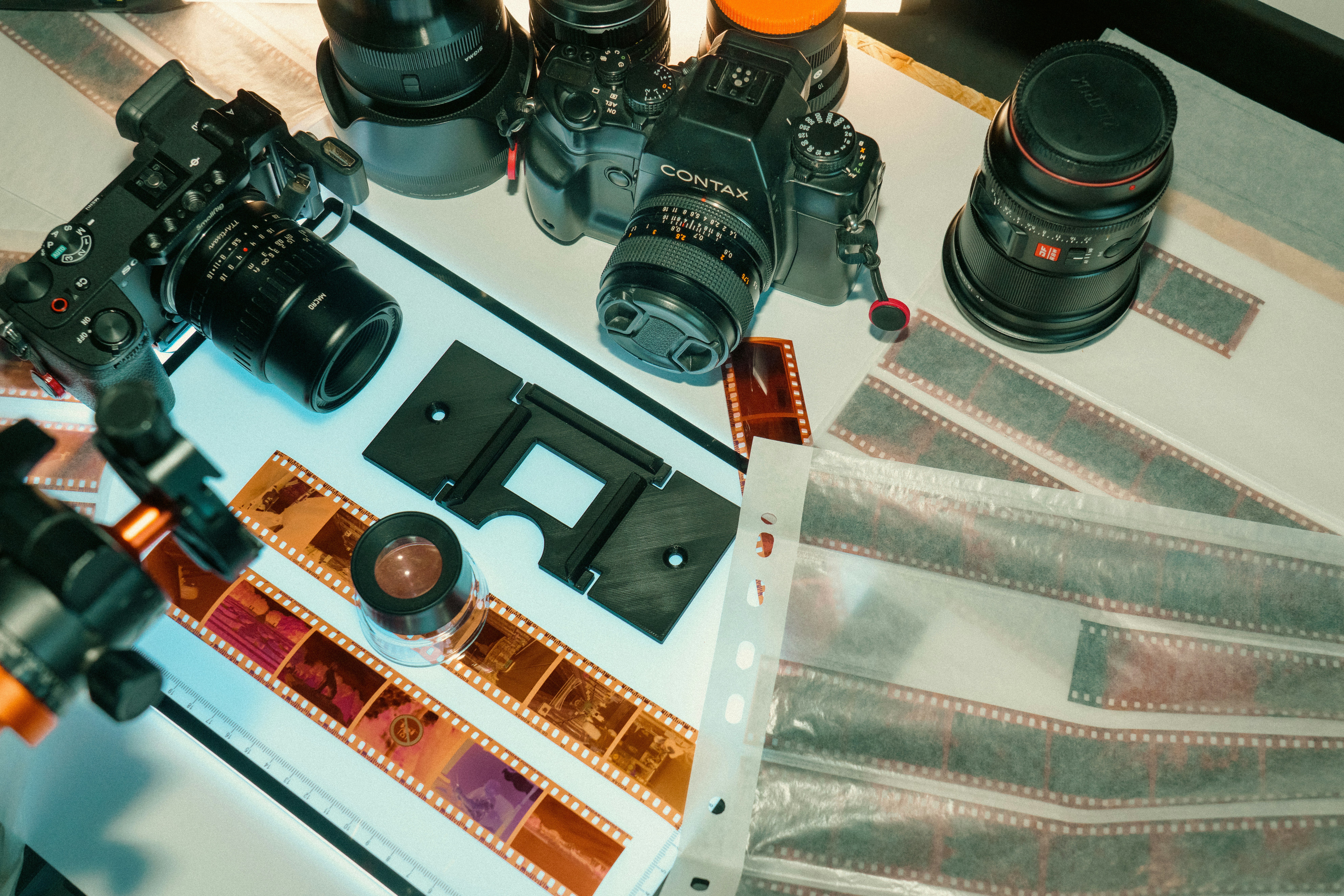 Kamera dan strip film diletakkan di atas meja.