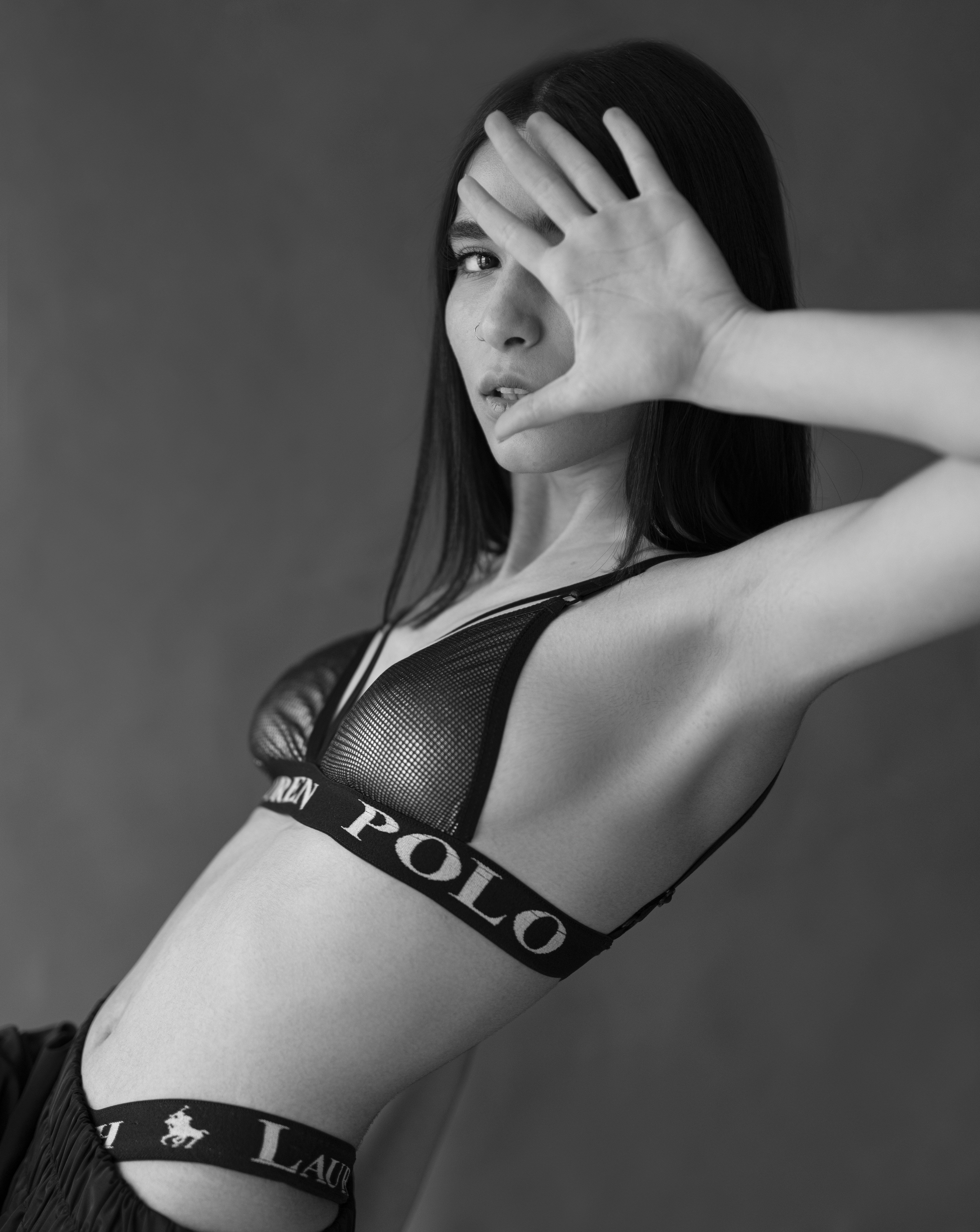 Woman in bra covers face with hand