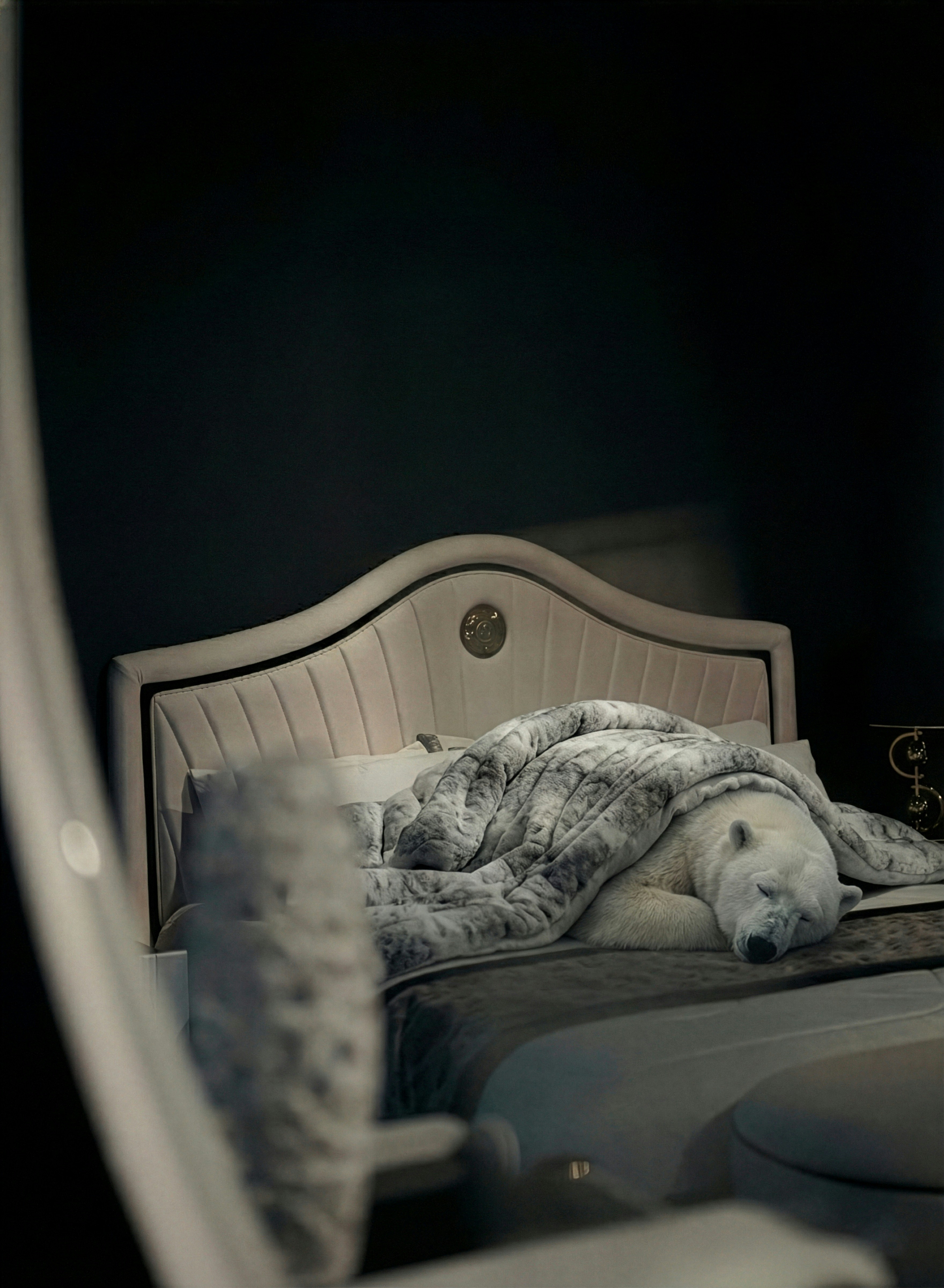 A stuffed polar bear sleeps on a bed.