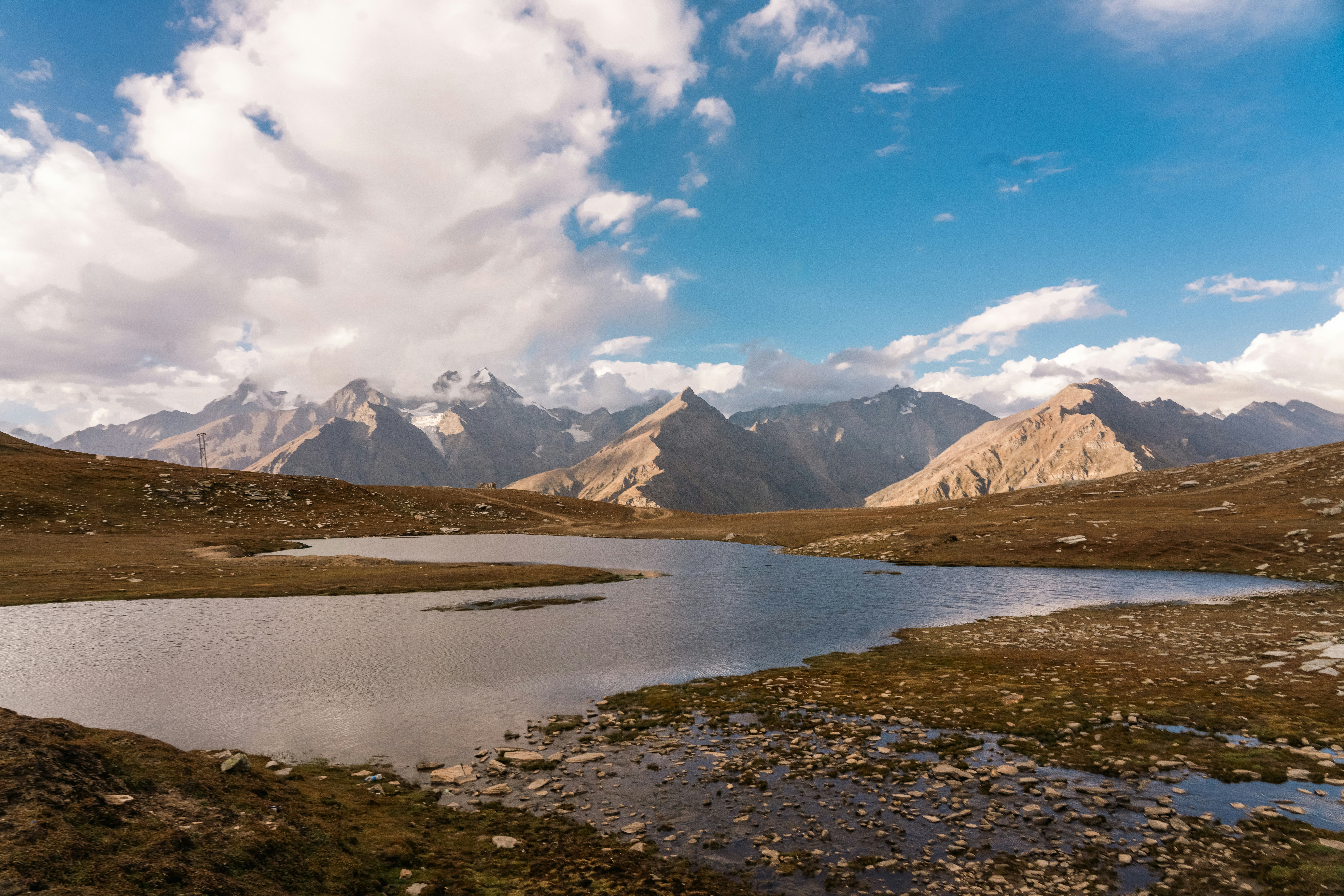 A serene mountain lake under a partly cloudy sky.