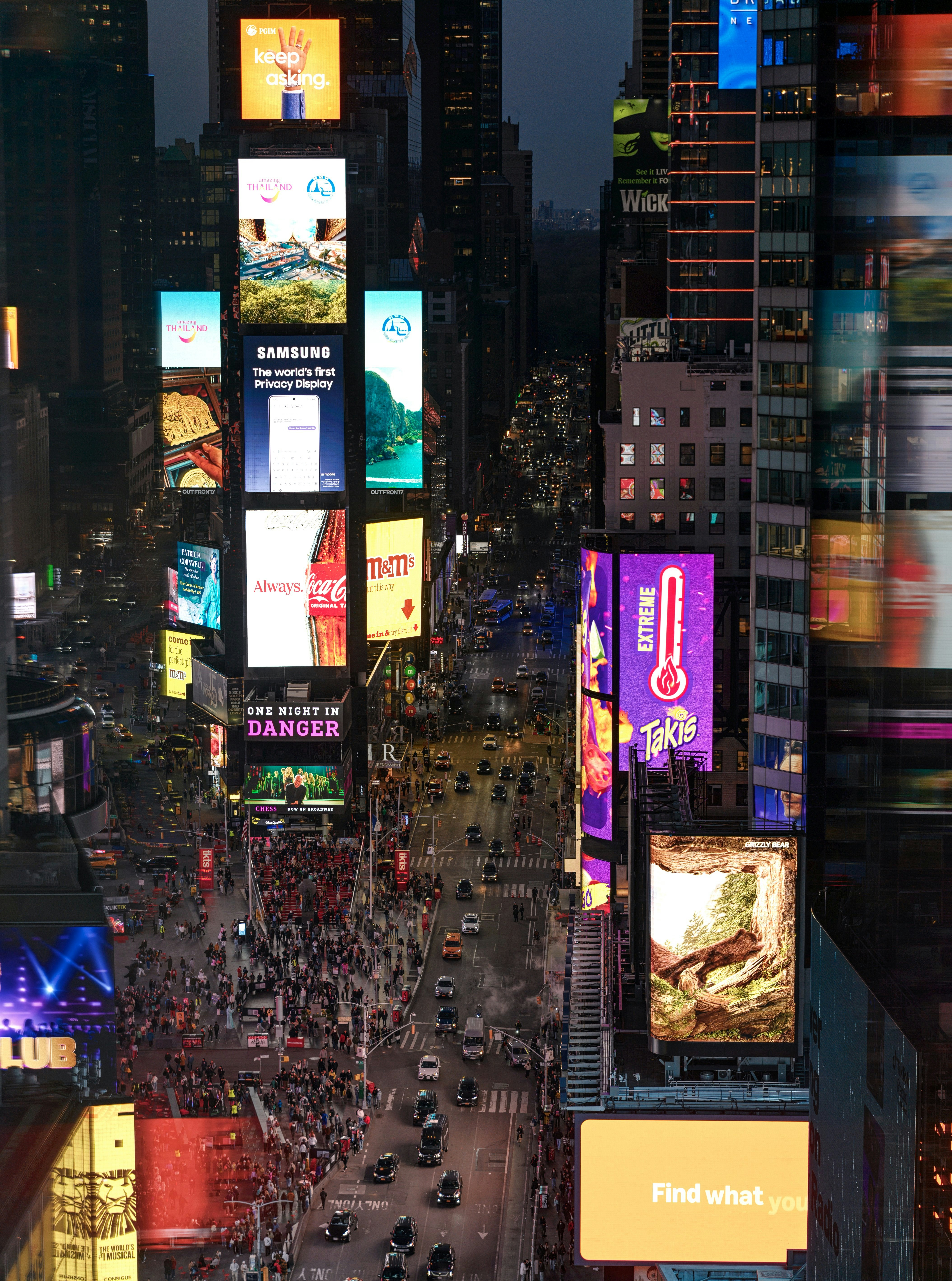 Times Square, con vallas publicitarias brillantes y calles concurridas por la noche.