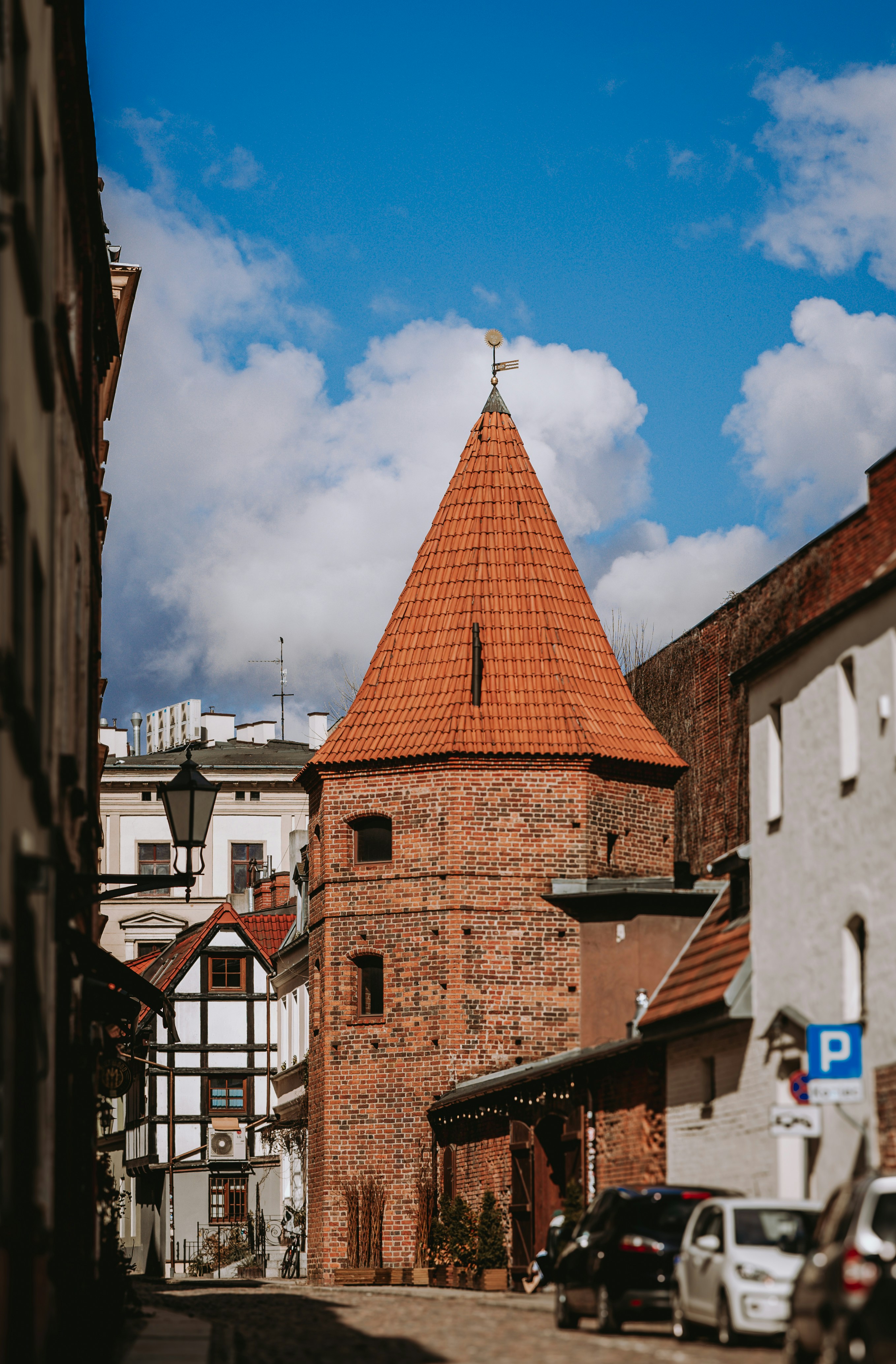 Old brick tower with red roof in european town