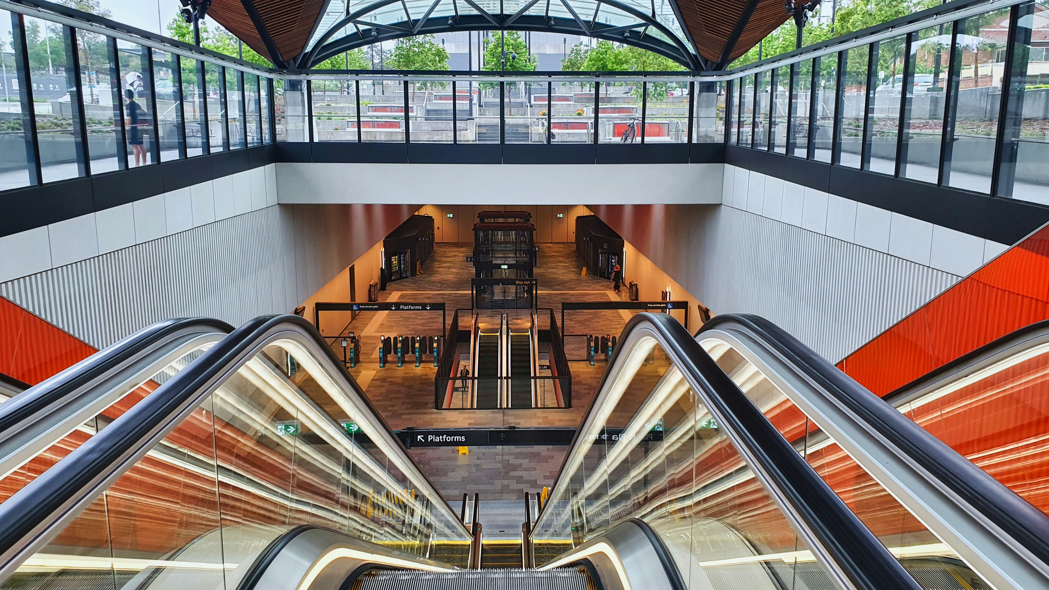 現代のエスカレーターが地下鉄駅へ降りていく様子。