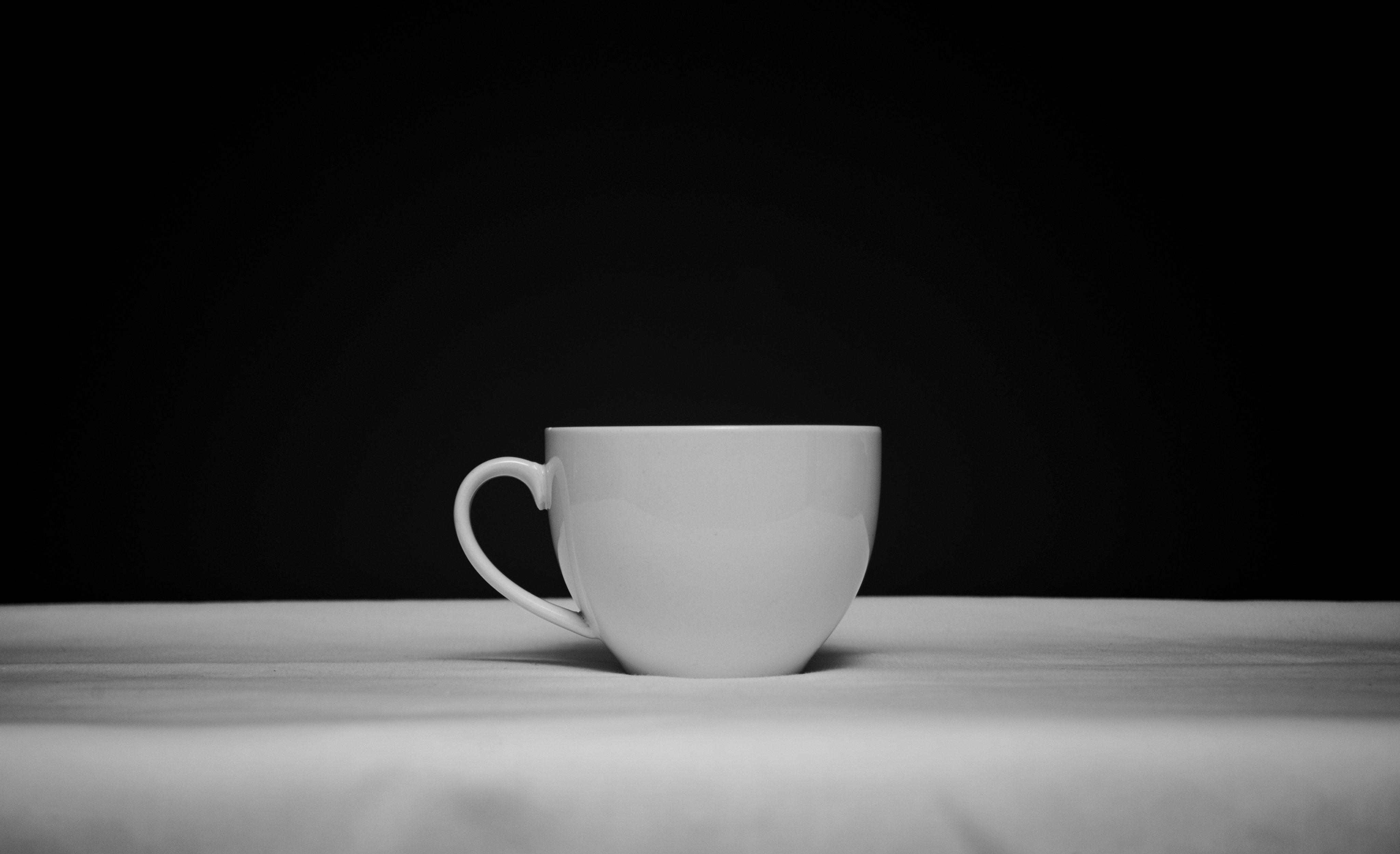 白い表面に置かれた白いコーヒーカップ。