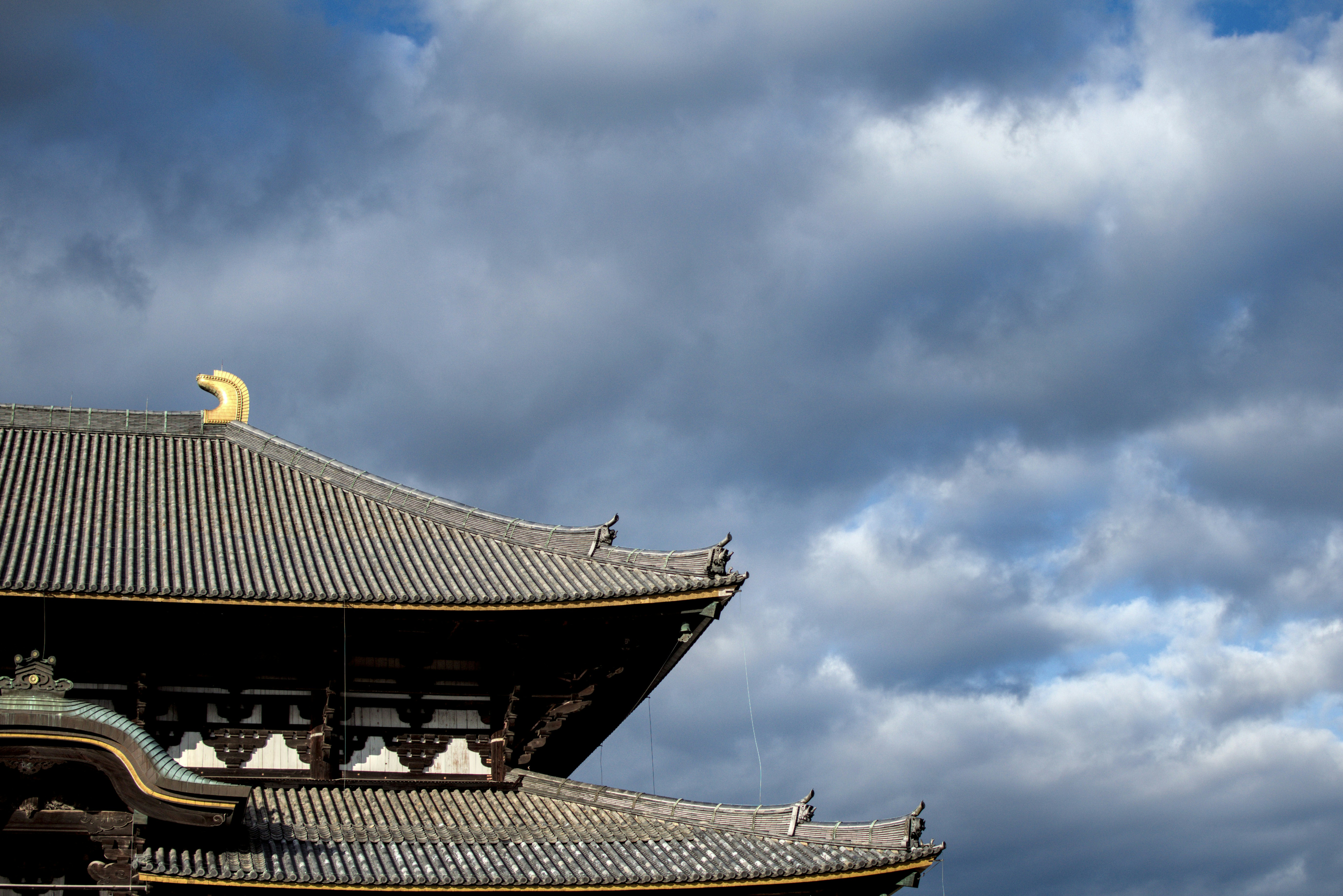 Tejado tradicional de templo japonés contra un cielo nublado