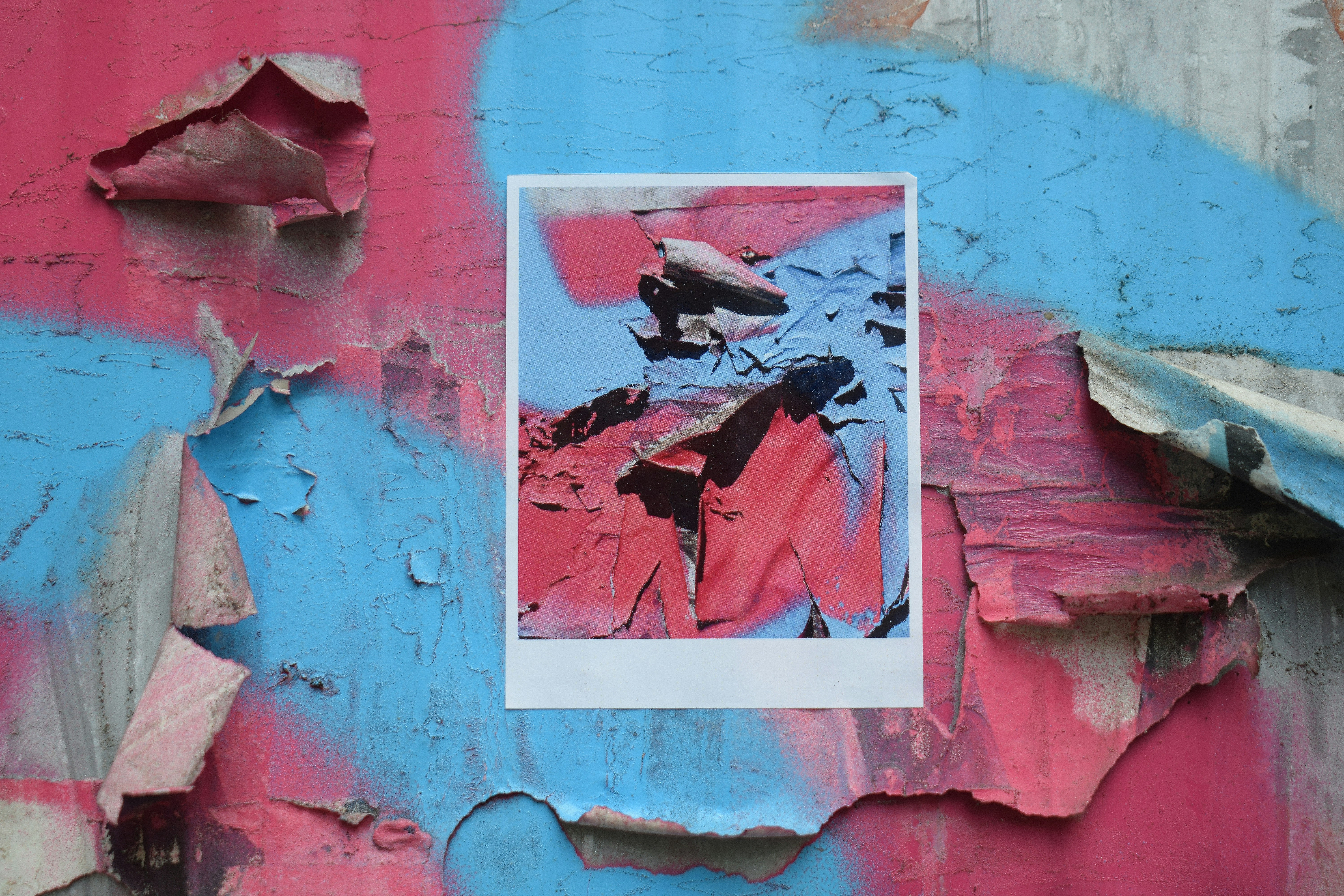 Peeling paint on a pink and blue wall