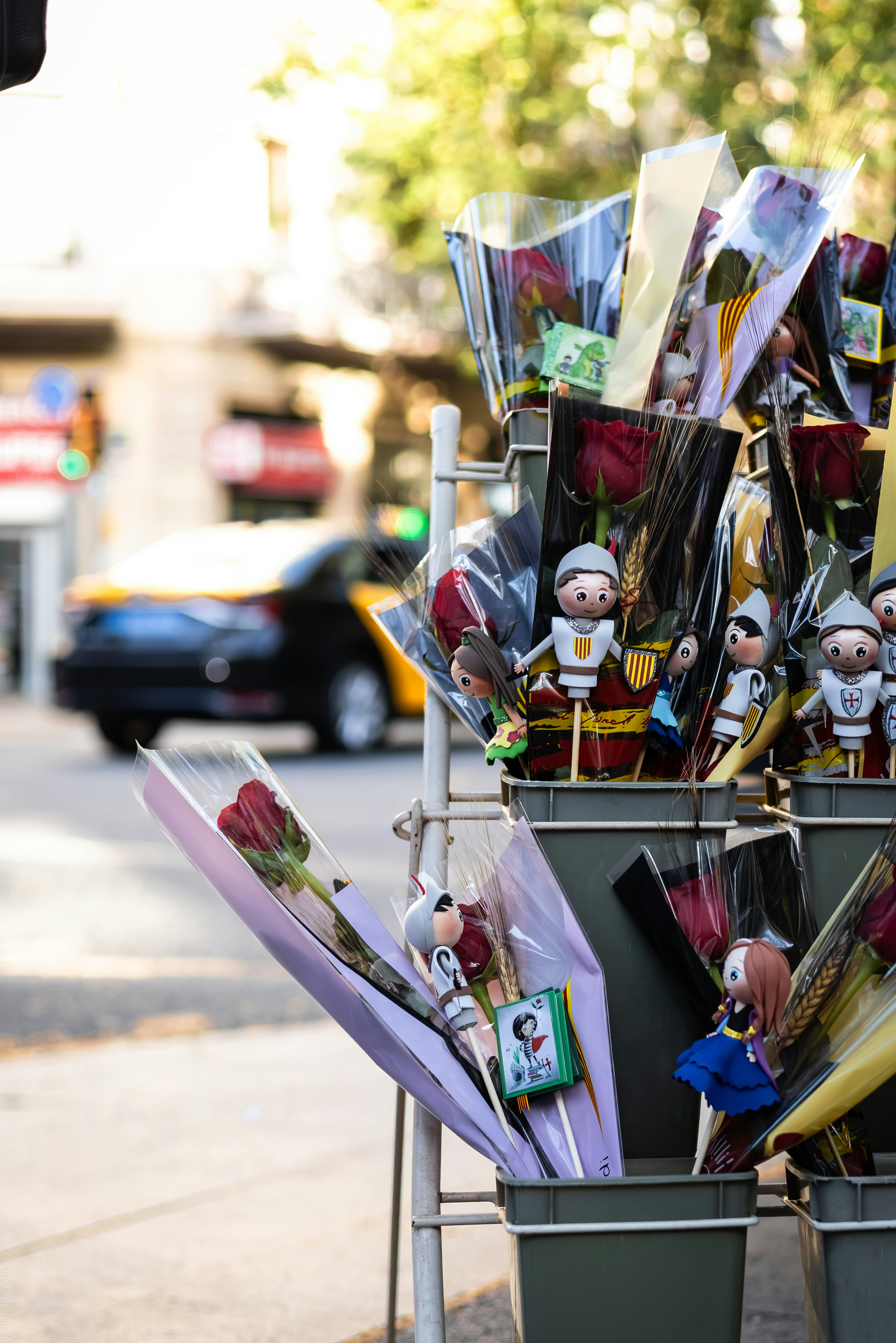 Rosen und kleine Figuren, die auf einem Straßenstand ausgestellt sind.