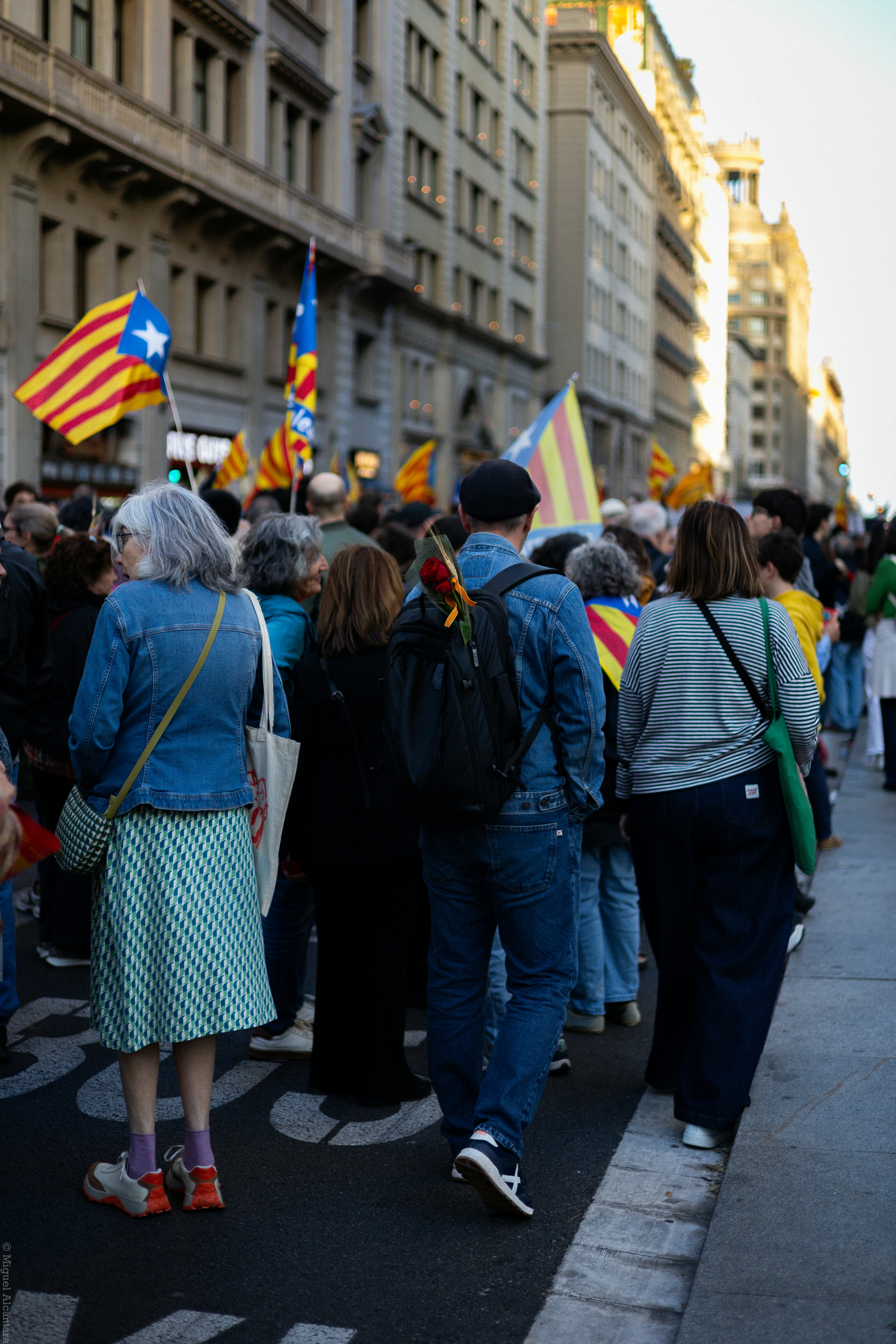 Menschen, die katalanische Flaggen bei einer Straßendemonstration halten.