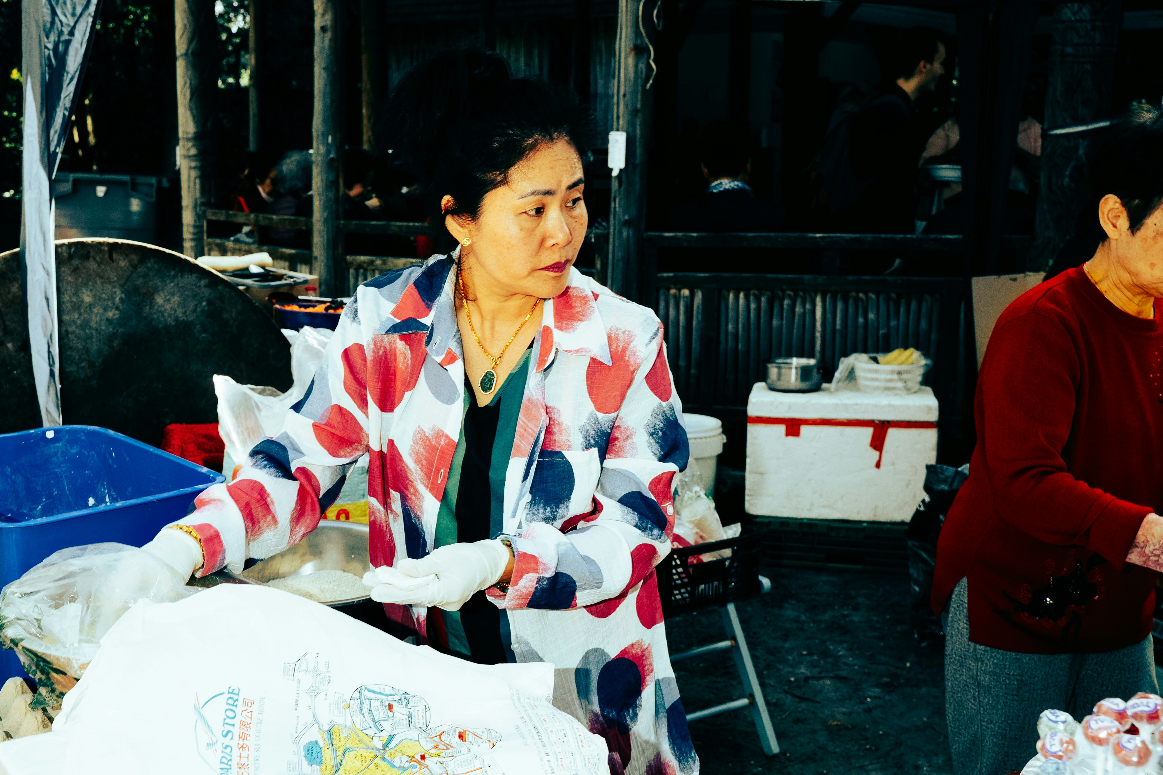 Donna con una giacca colorata a una bancarella del mercato.