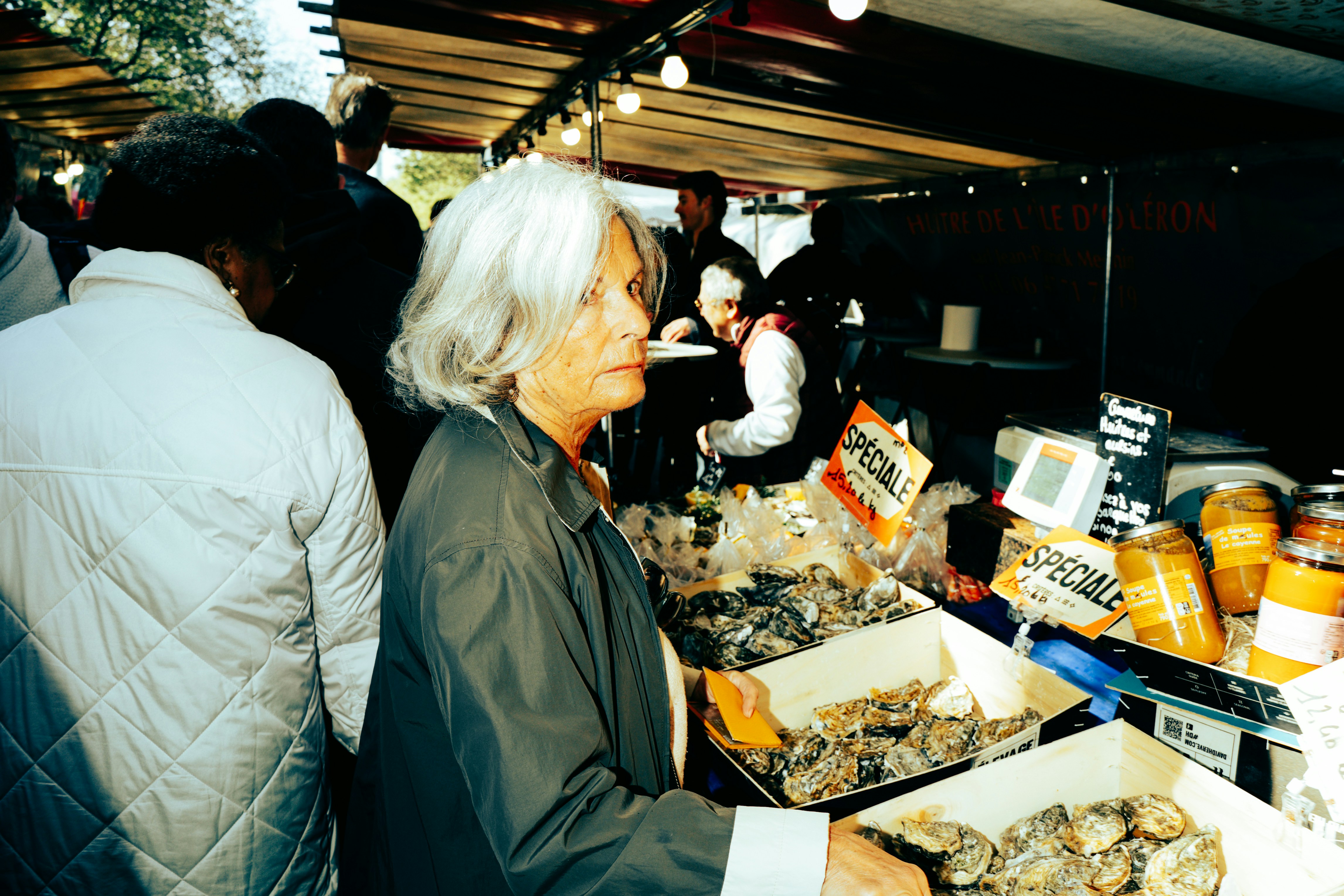 Donna che fruga ostriche in un mercato all'aperto.