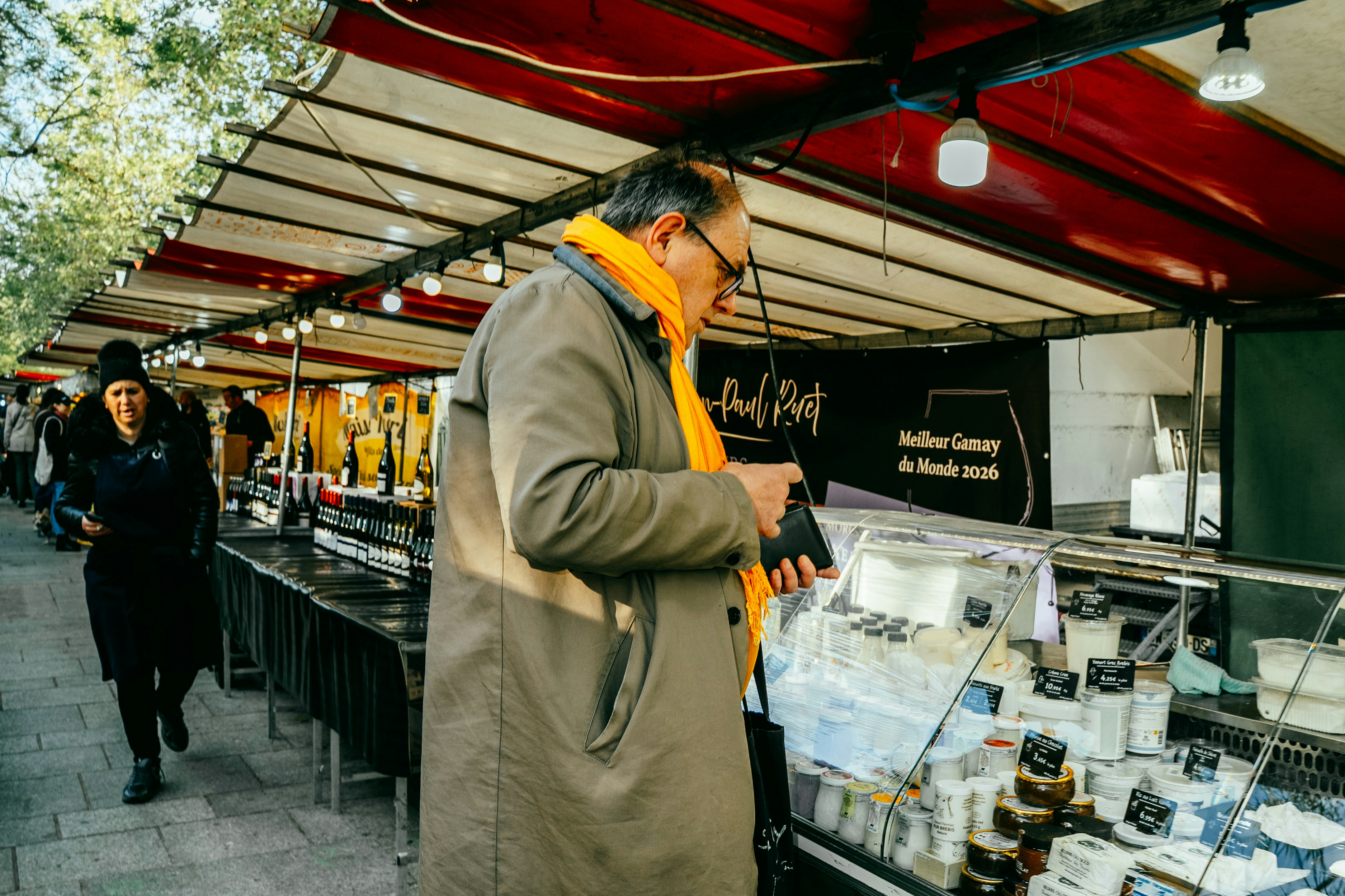 Uomo che sfoglia bancarelle di cibo in un mercato all'aperto.